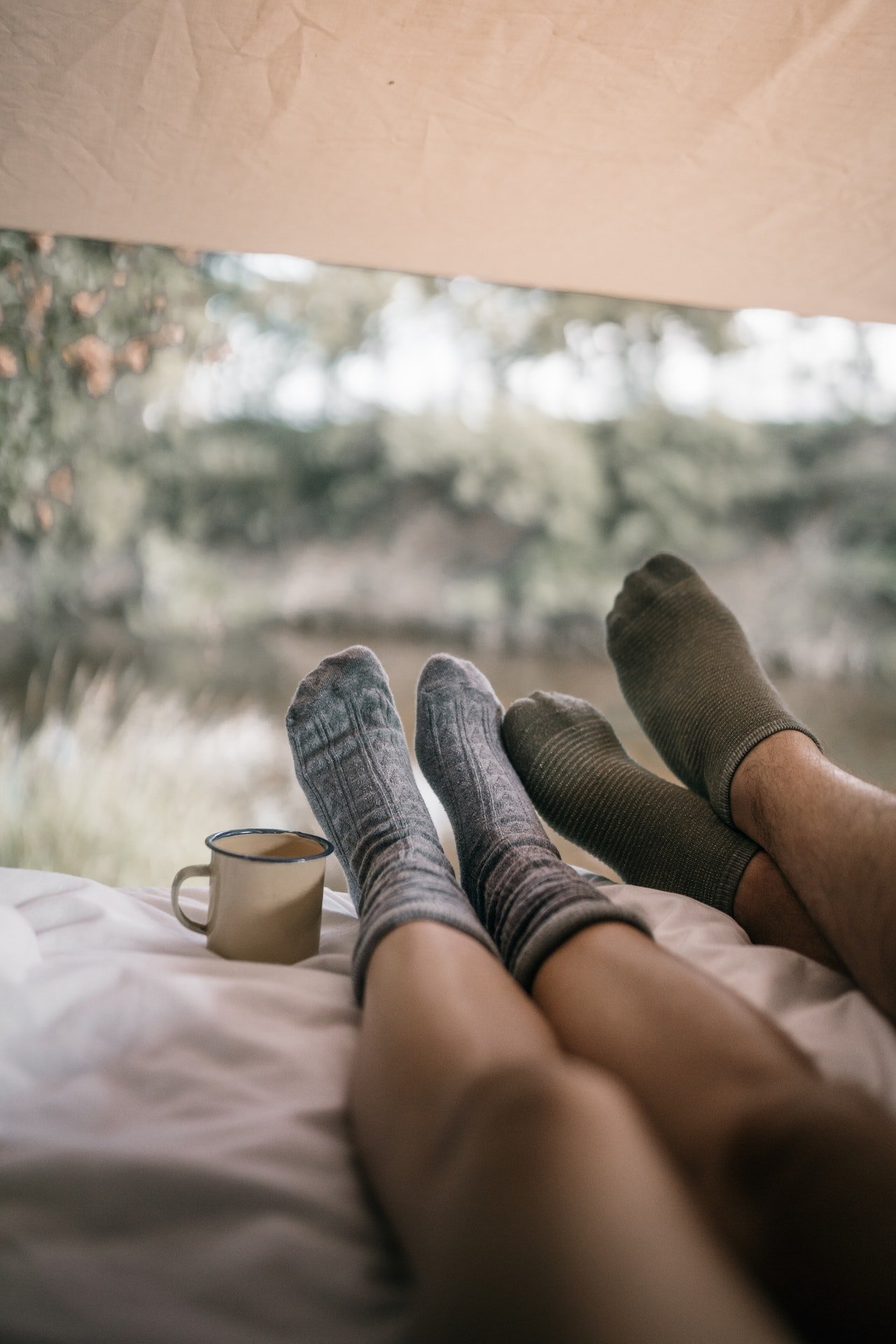 Photo of two people showing their legs on a bed | Photo: Pexels