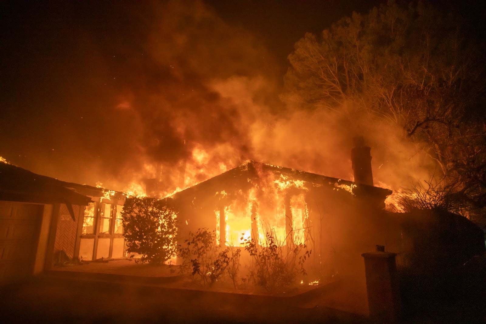 Flames from the Los Angeles wildfires burning a home during a powerful windstorm on January 8, 2025. | Source: Getty Images