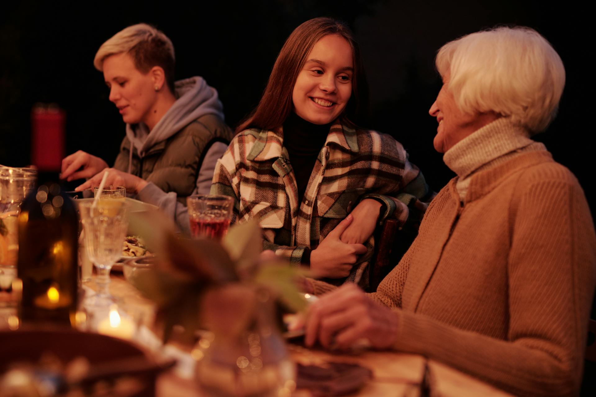 A young woman conversing with an elderly lady at the dinner table | Source: Pexels