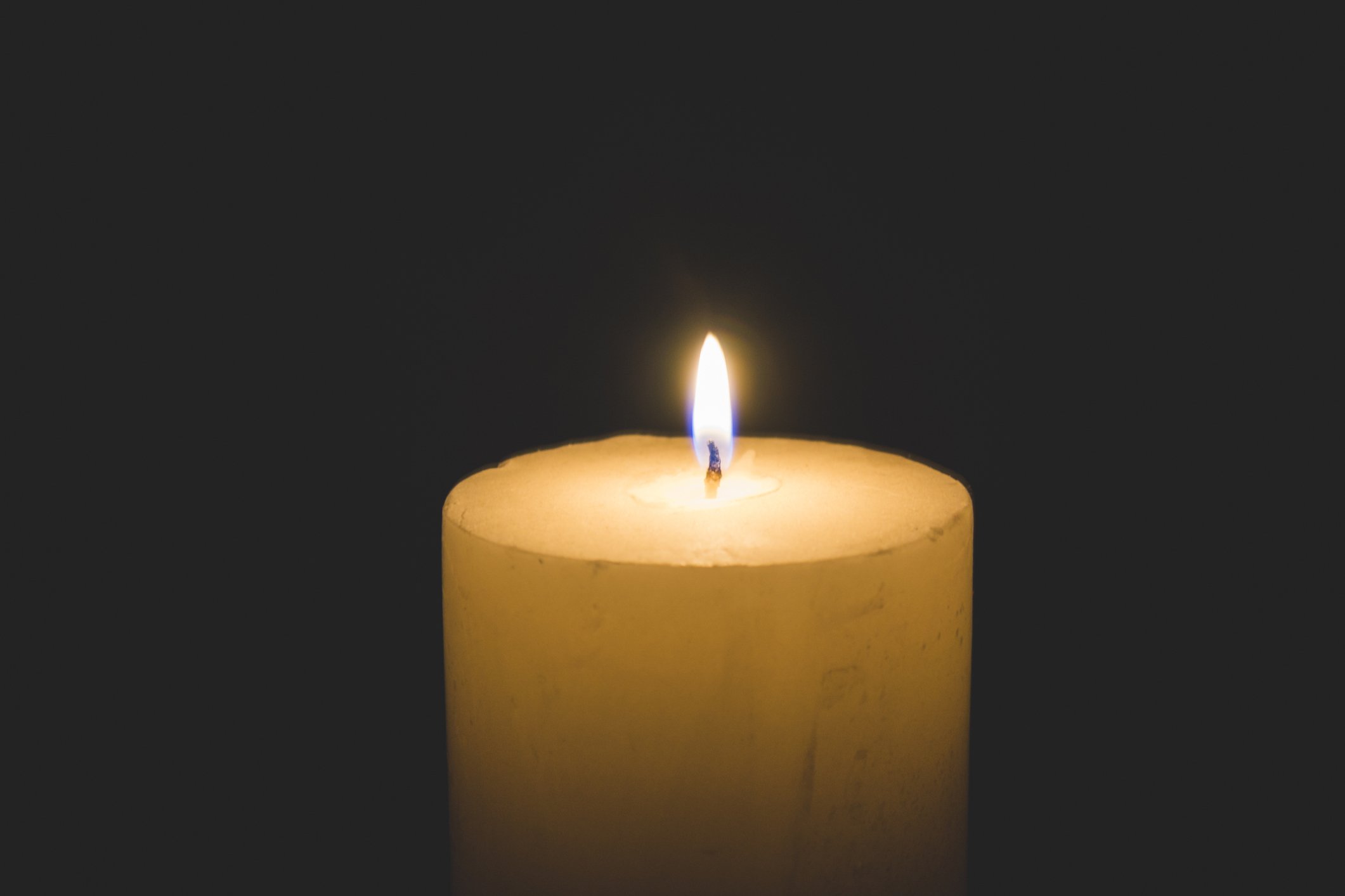 Eine kleine Kerze brennt im Dunkeln. I Quelle: Getty Images
