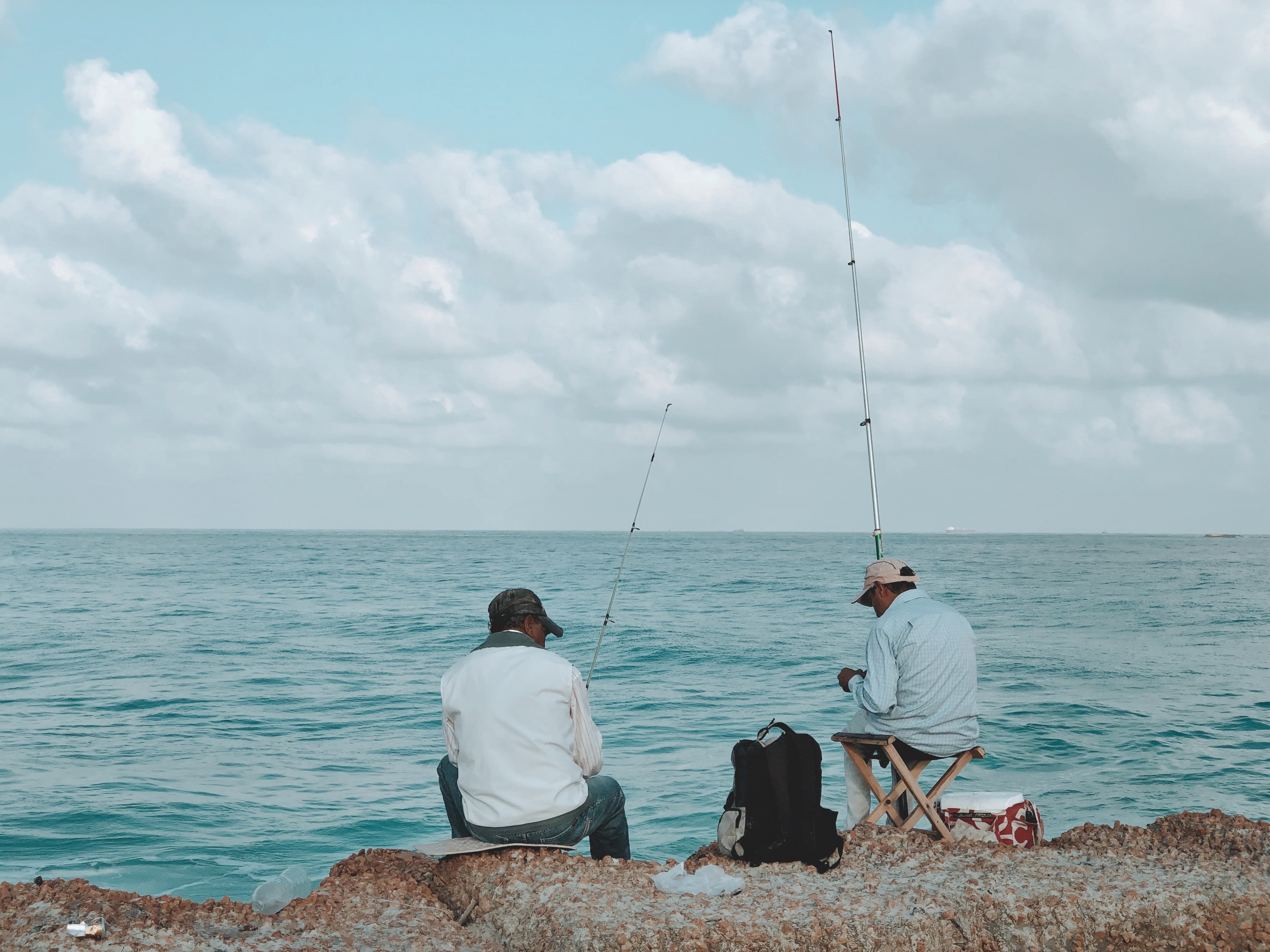 A couple of men fishing by the shore | Source: Unsplash.com