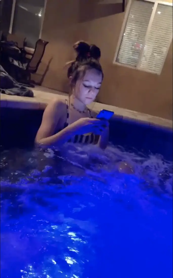 Austin's girlfriend is in the backyard jacuzzi texting, as seen in a video dated February 24, 2021 | Source: TikTok/@snow5_0