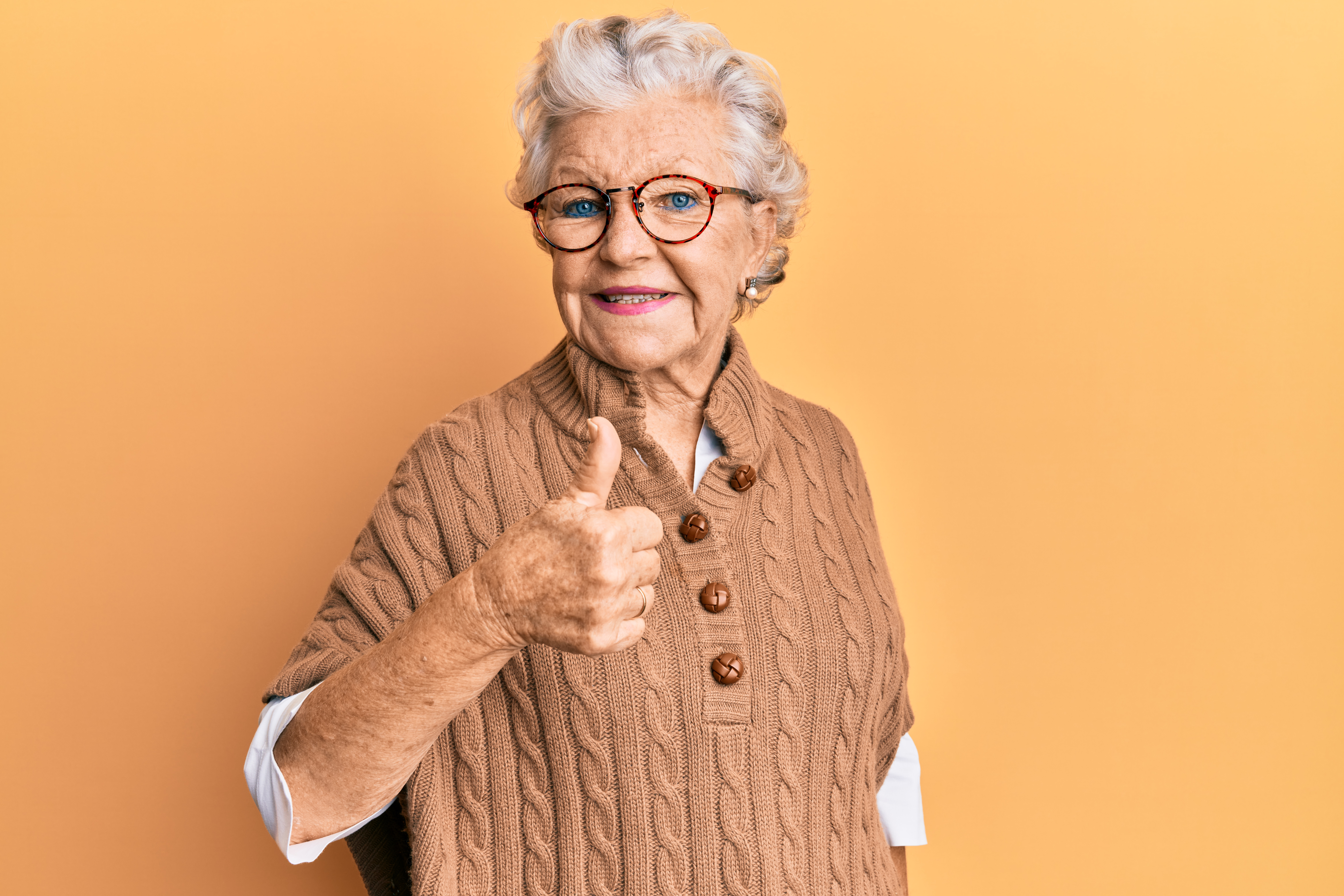 A smiling senior doing a thumbs up | Source: Shutterstock