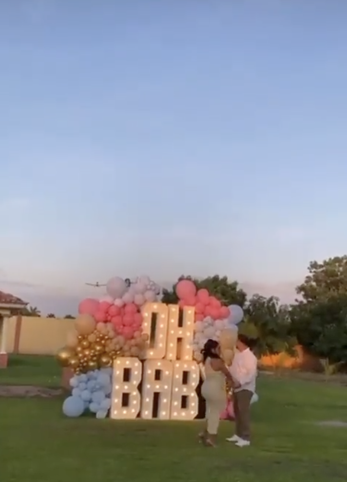 A couple stand in front of a sign saying "Oh Baby" waiting for the child's gender to be revealed | Source: twitter.com/NRNoticiasSIN