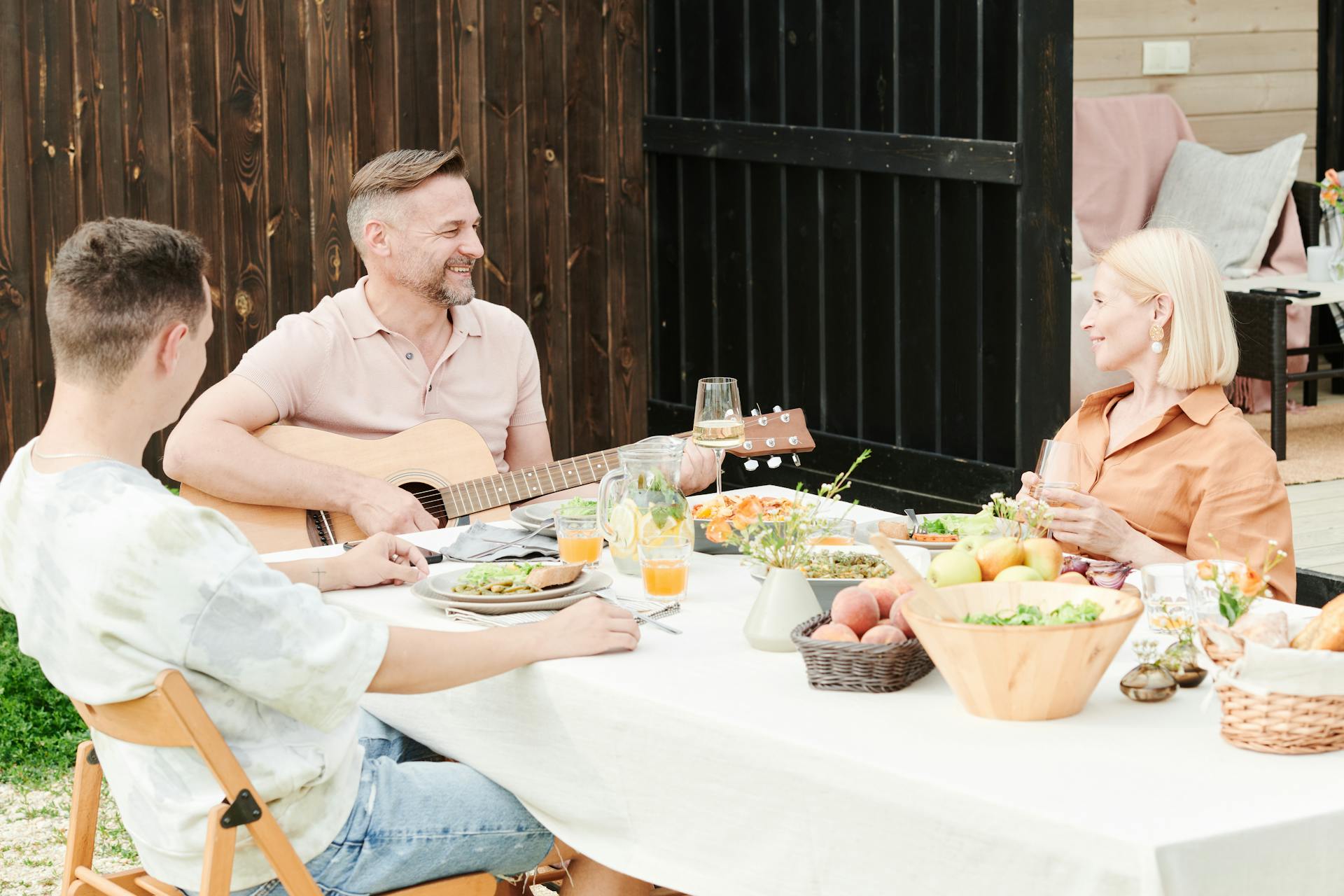 A man playing a guitar during a family dinner | Source: Pexels