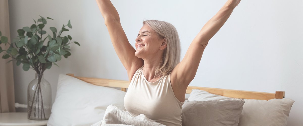 Mujer estirándose en su cama. | Foto: Shutterstock