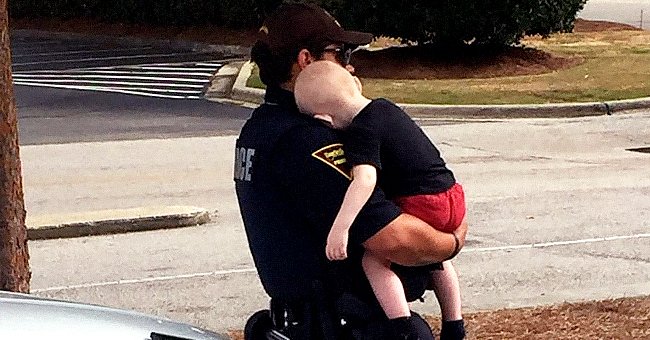 A police officer consoles a 1-year-old baby abandoned by his parents following heroin overdose. | Photo: facebook.com/Fayetteville.Police