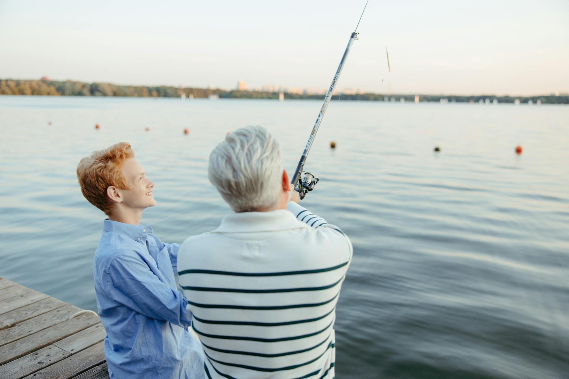 An elderly man and a boy fishing by the dock | Source: Pexels