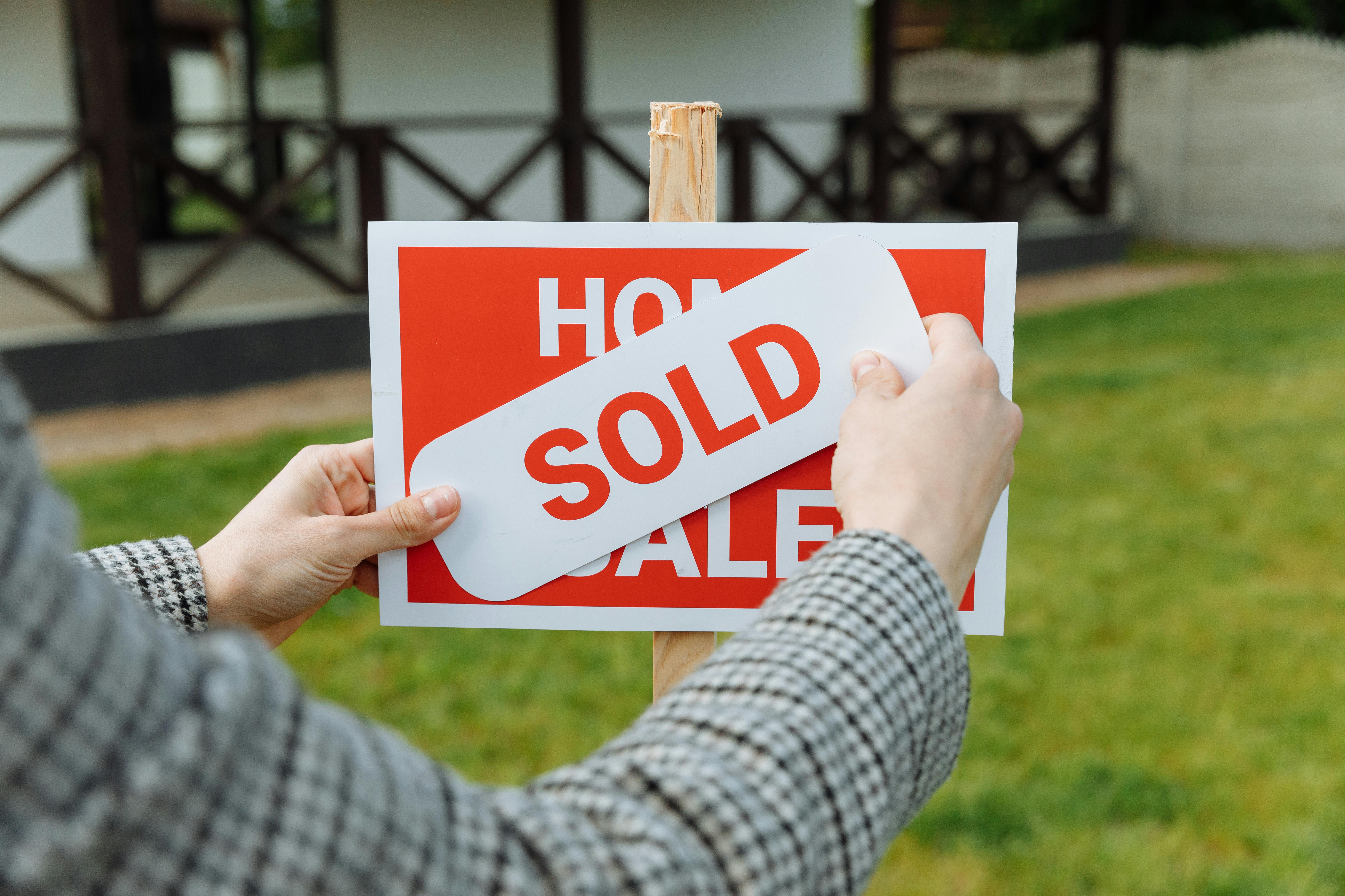 A person marking a house that has been sold | Source: Pexels