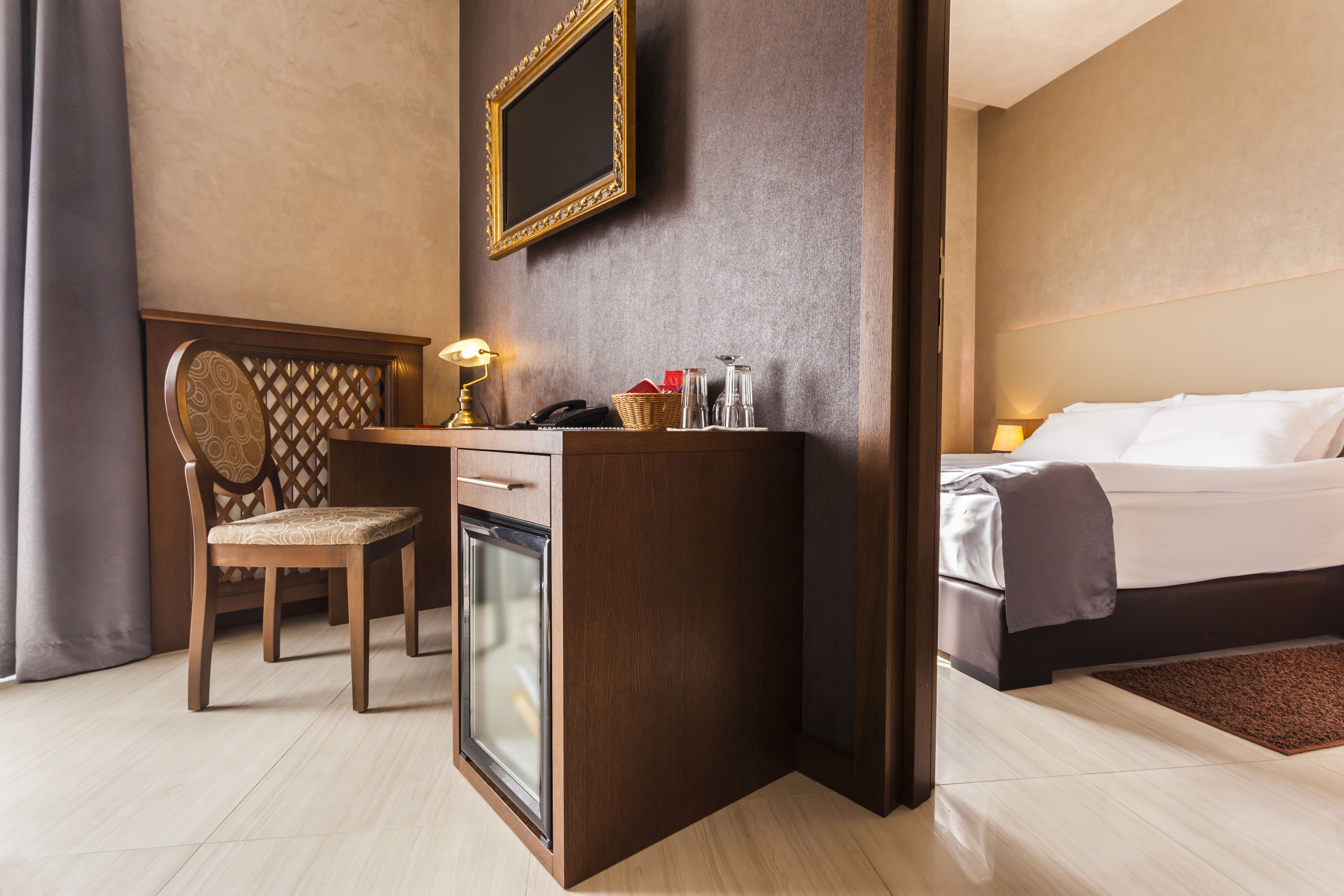 Luxury hotel room interior with mini bar in brown tones. | Source: Shutterstock