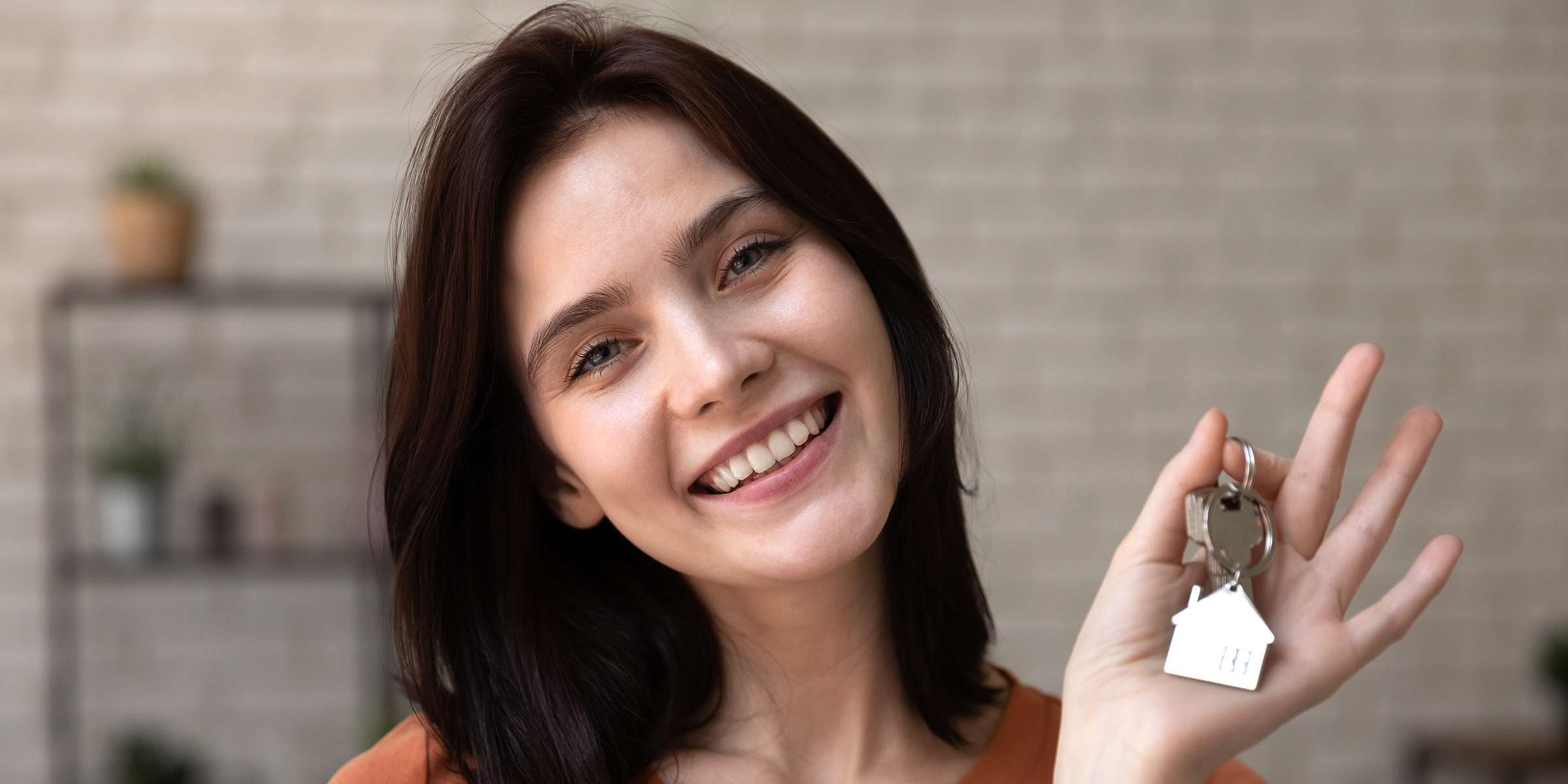 A young woman holding house keys | Source: Shutterstock