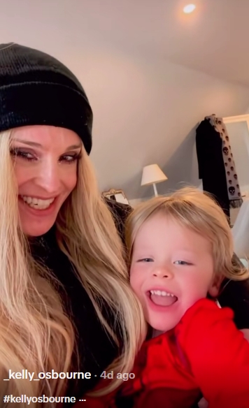 Beaming at the camera in a post dated February 21, 2026, Kelly Osbourne cradles her son close as both flash wide smiles for a cosy moment at home. Dressed in a black beanie and dark top, with her long blonde hair falling over her shoulders, she leans into the frame while her son, in a bright red jumper, grins mid-laugh. | Source: TikTok/_kelly_osbourne