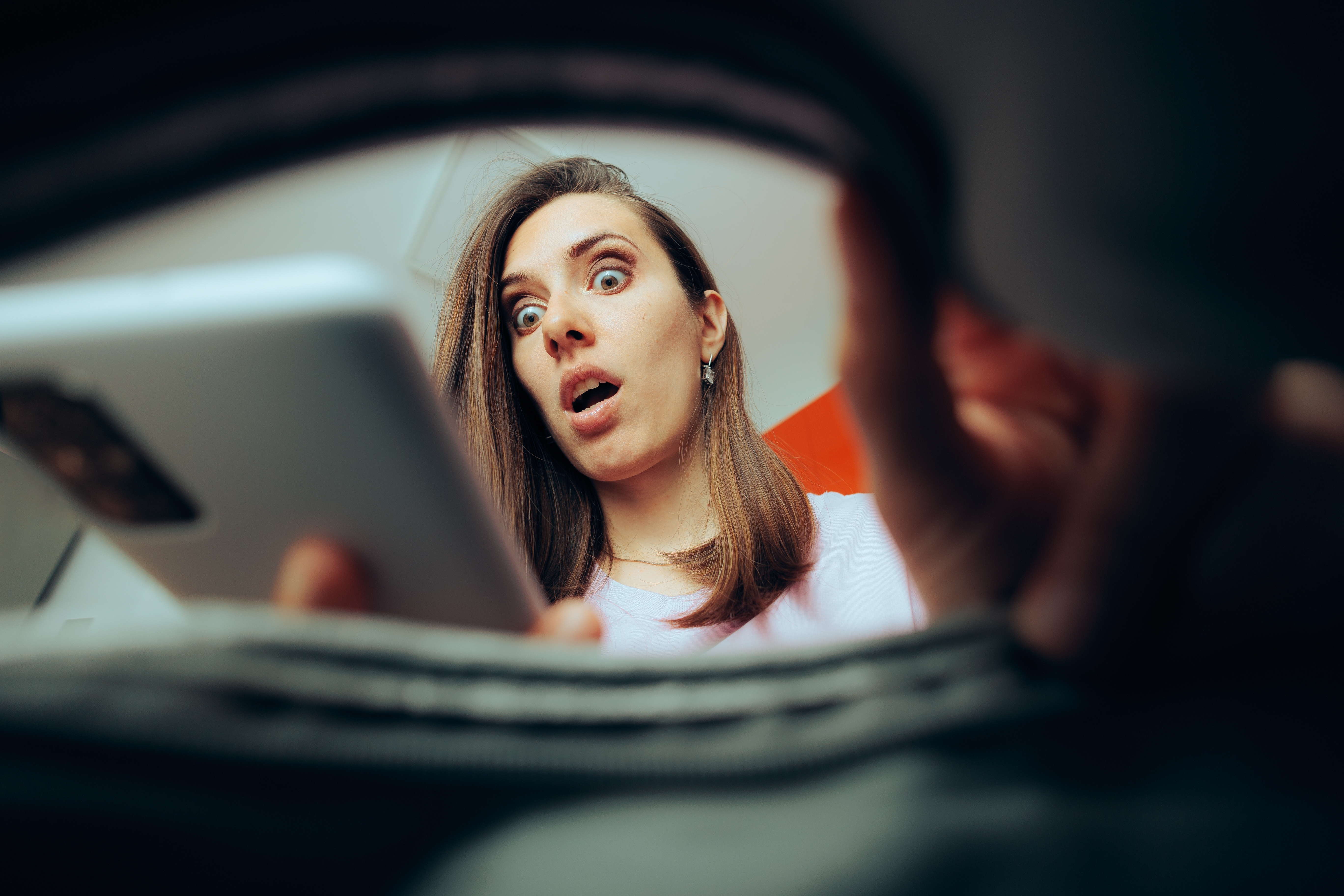 A surprised woman checking her phone ringing | Source: Shutterstock