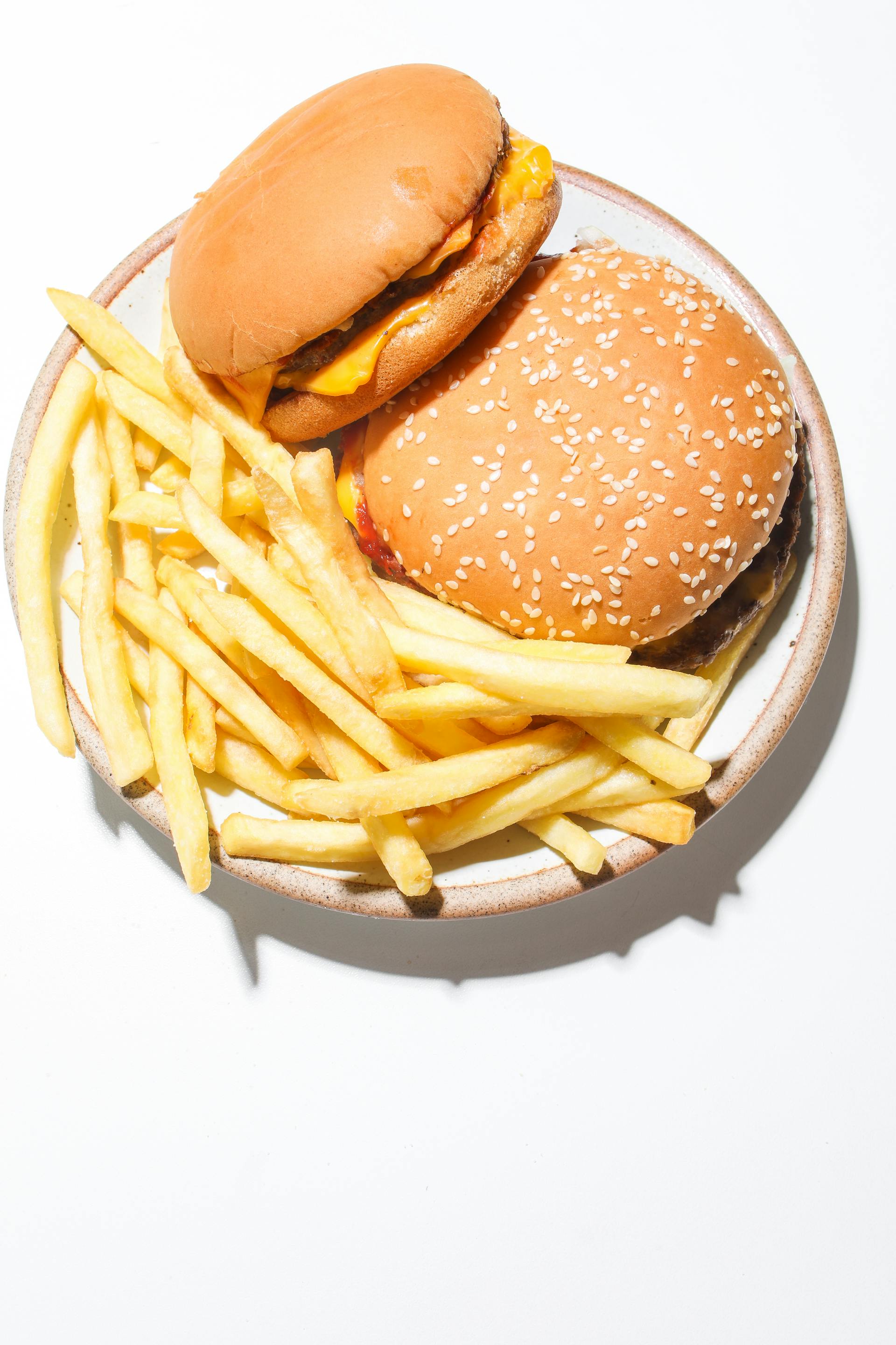 Burgers and fries served on a plate | Source: Pexels
