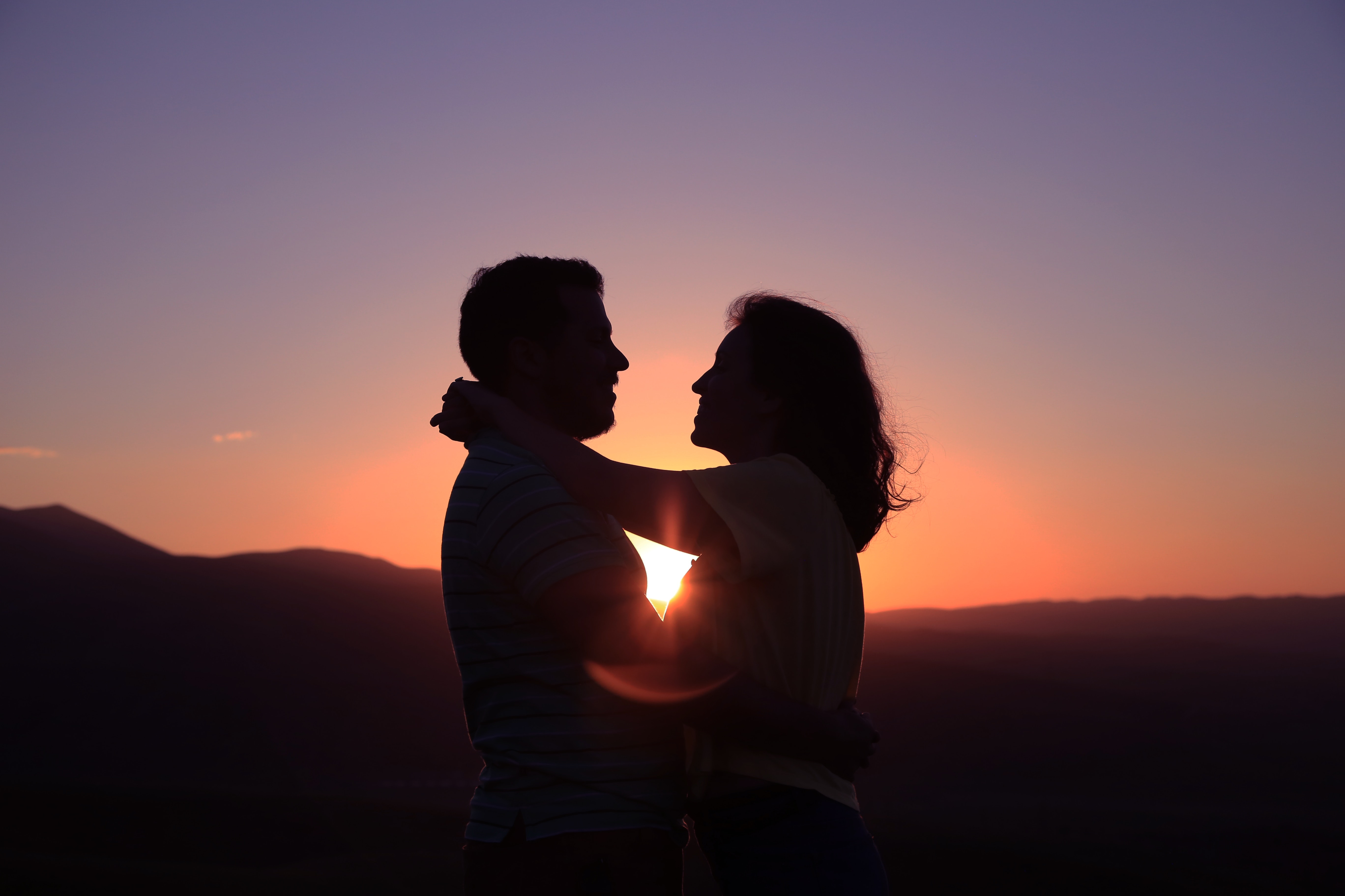A couple standing in front of a sunset. | Source: Unsplash