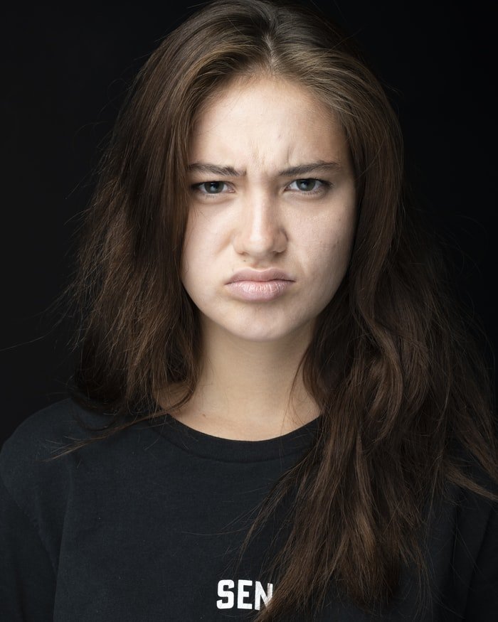 Une jeune femme fronçant les sourcils. l Source : Unsplash