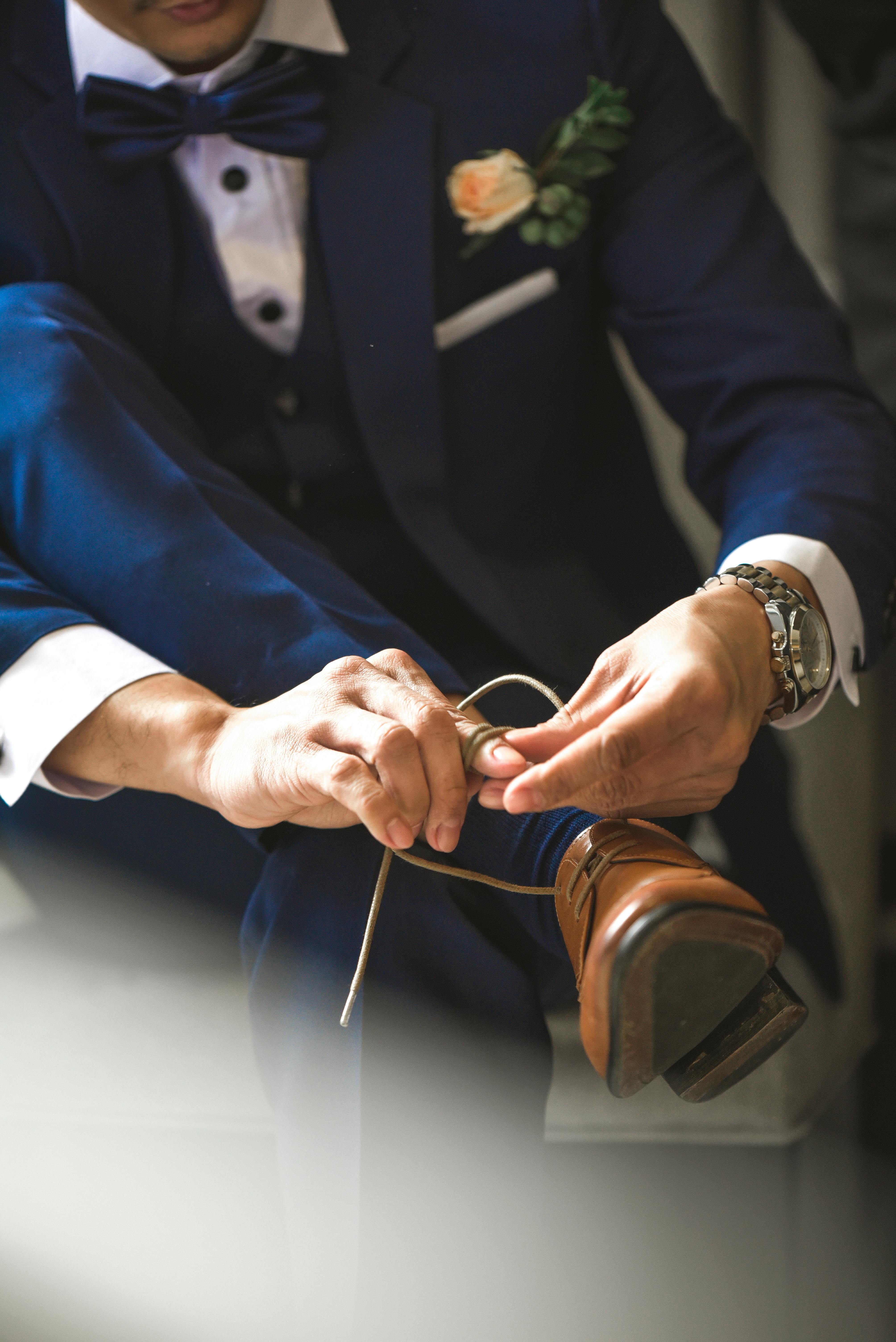 A groom tying his shoes | Source: Pexels