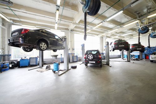 Cars in the service bay of an auto repair shop. | Source: Shutterstock.