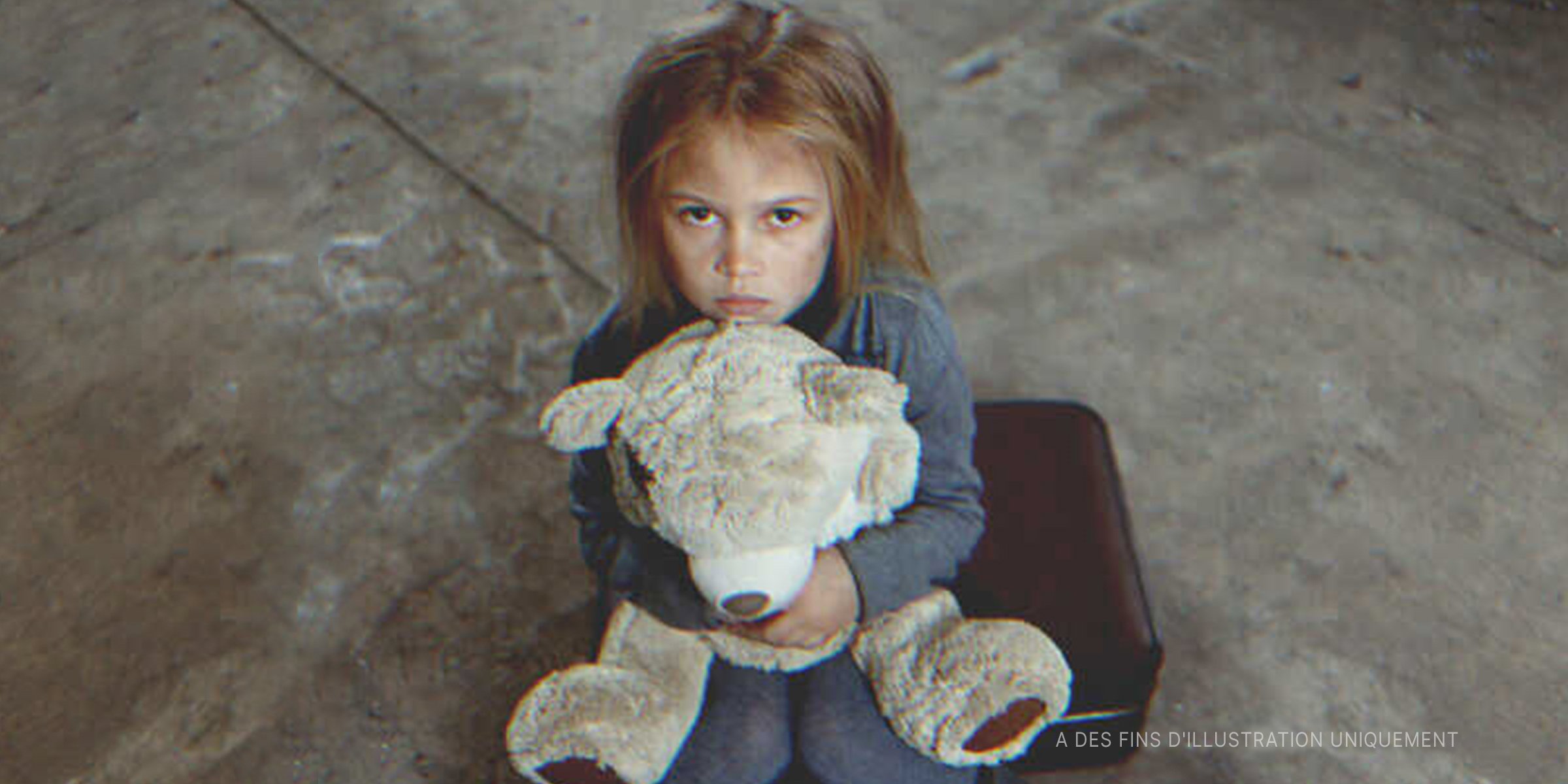 Une petite fille portant un nounours | Photo : Shutterstock