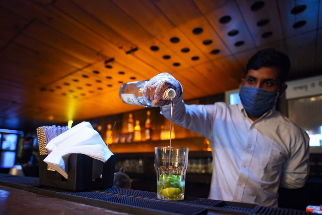Un barman au travail entrain de servir une boisson. |Photo : Getty Images