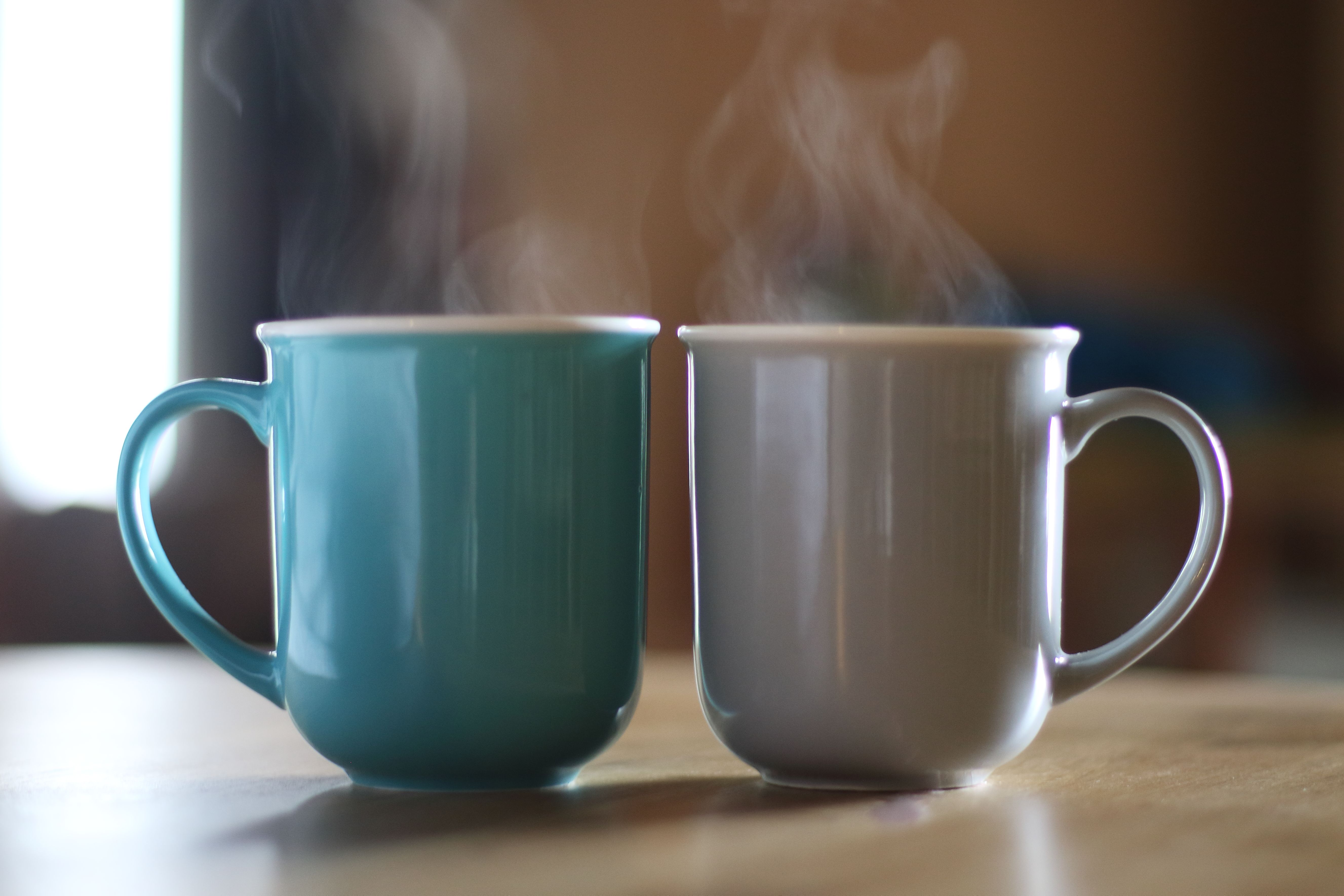 Two mugs with hot beverages inside. | Source: Getty Images