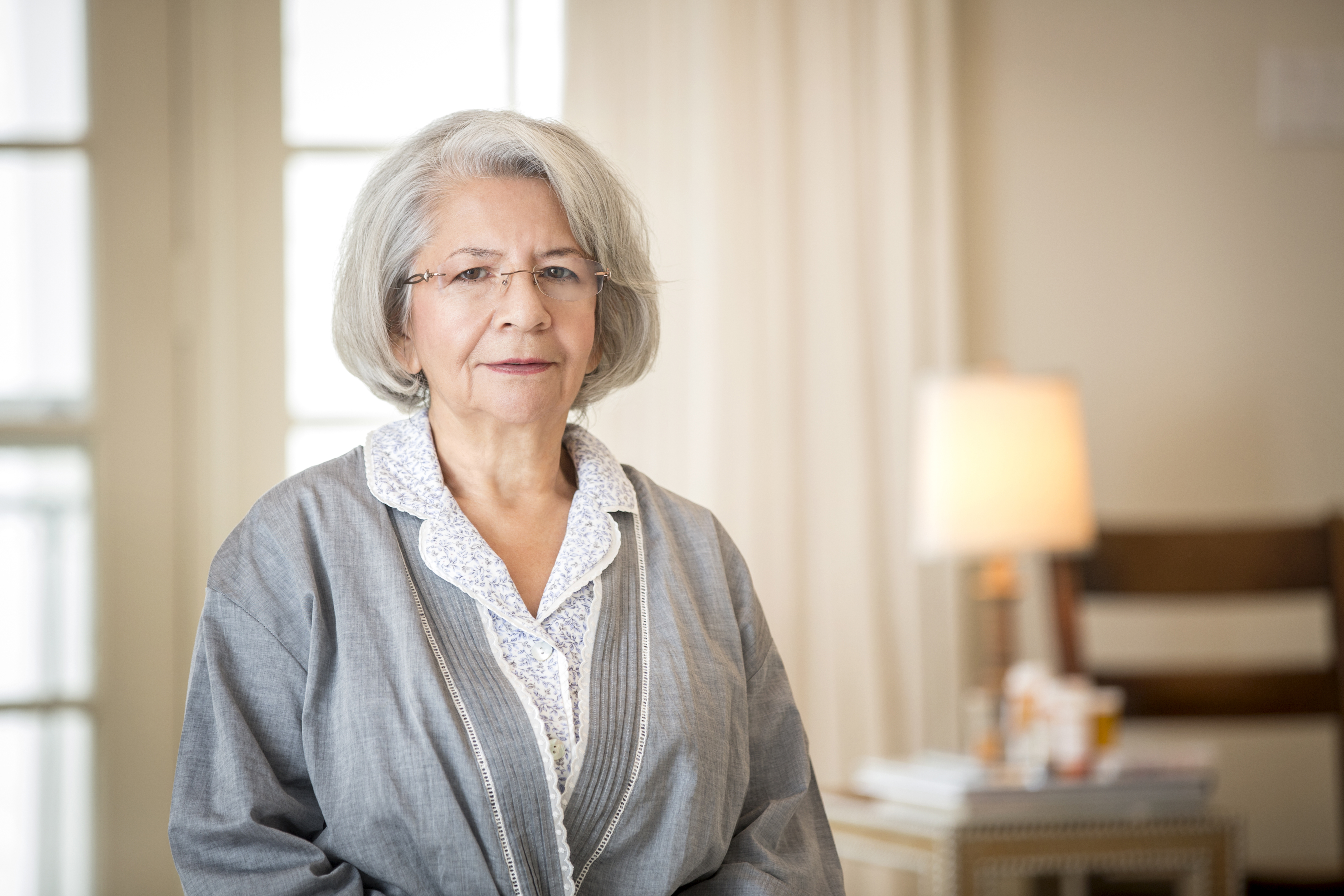 Older frowning Hispanic woman wearing bathrobe | Source: Getty Images