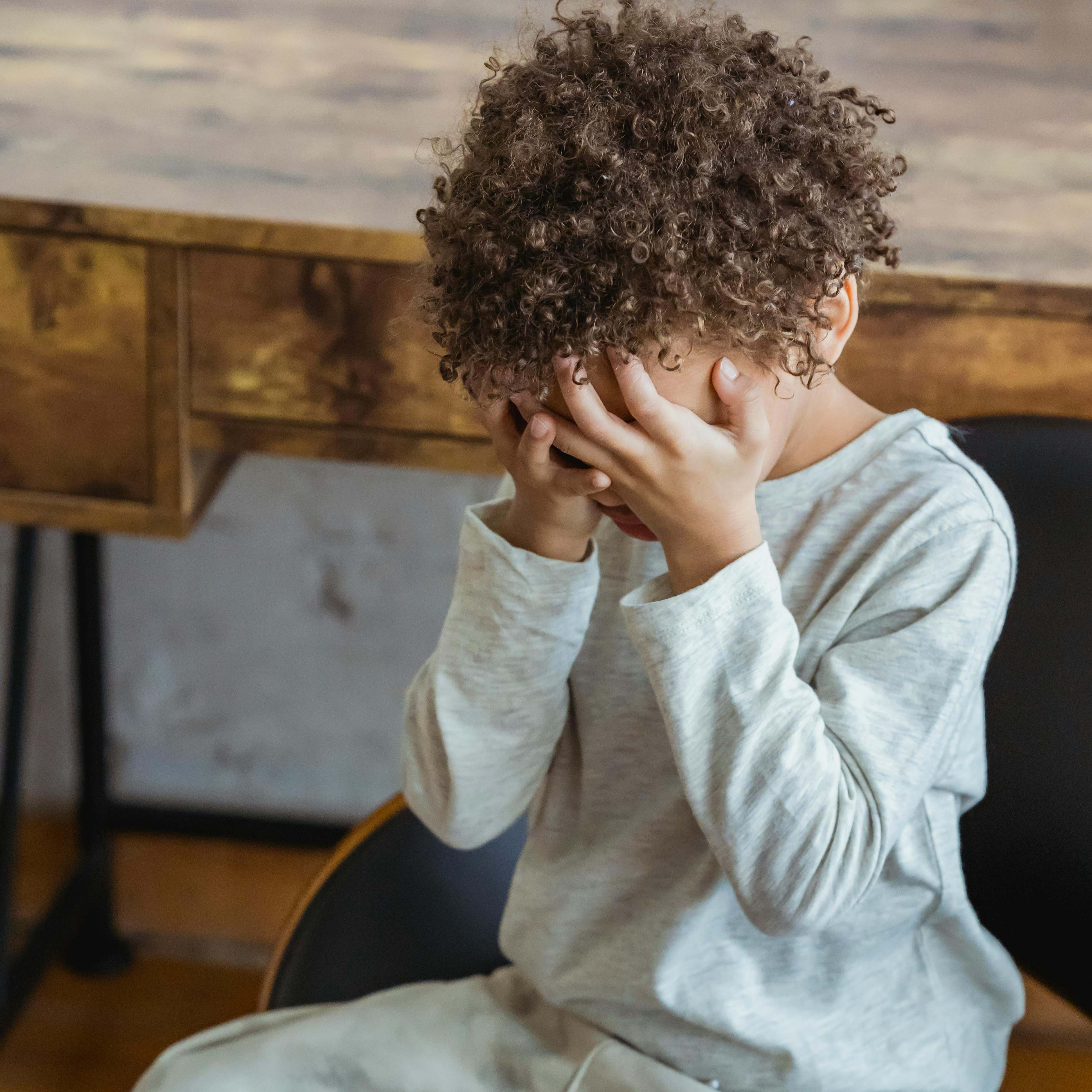 A young boy holding his head in despair | Source: Pexels