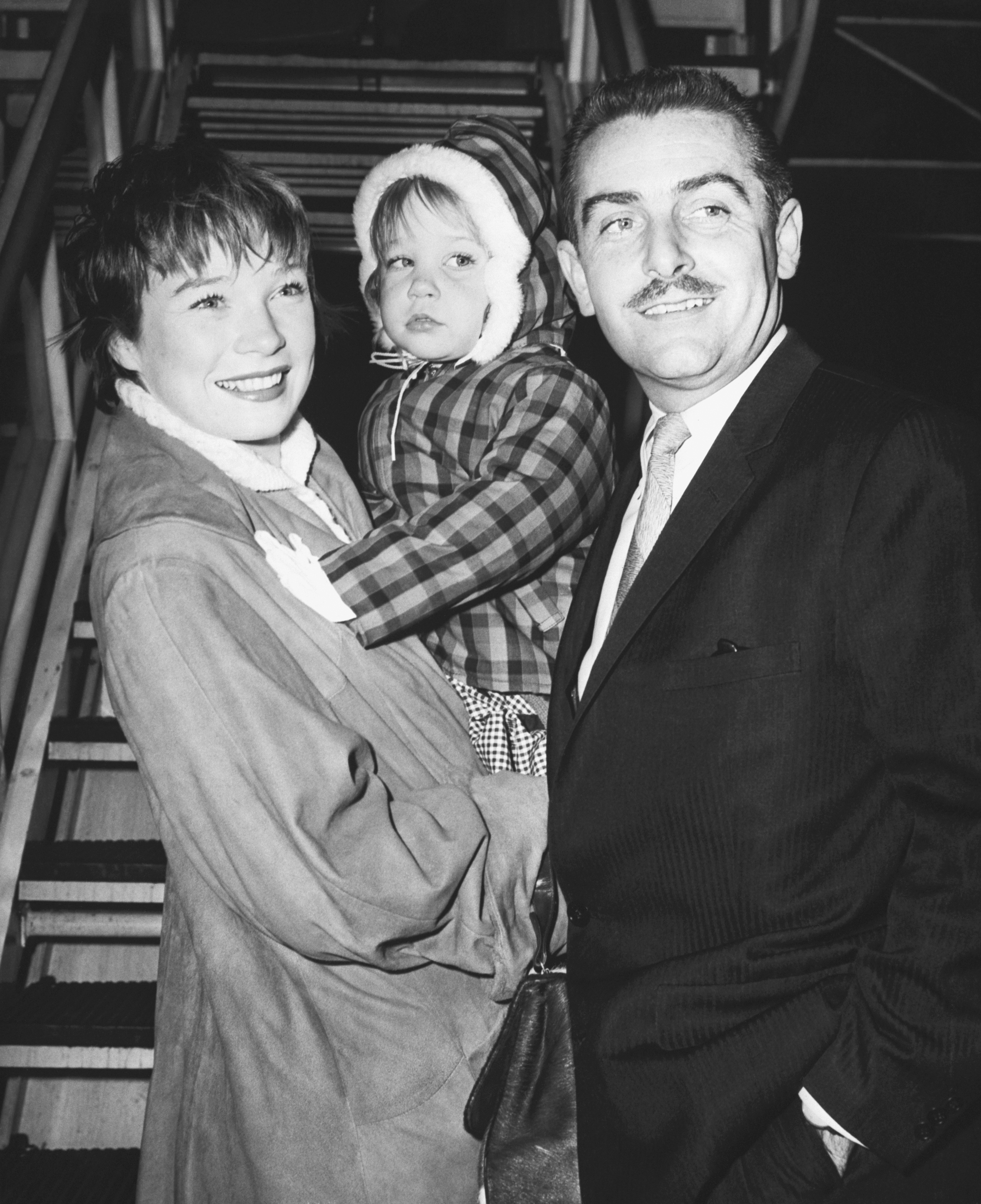 The actress pictured with Sachi and Steve Parker at Idlewild (later JFK) airport on April 1, 1959, in New York. | Source: Getty Images