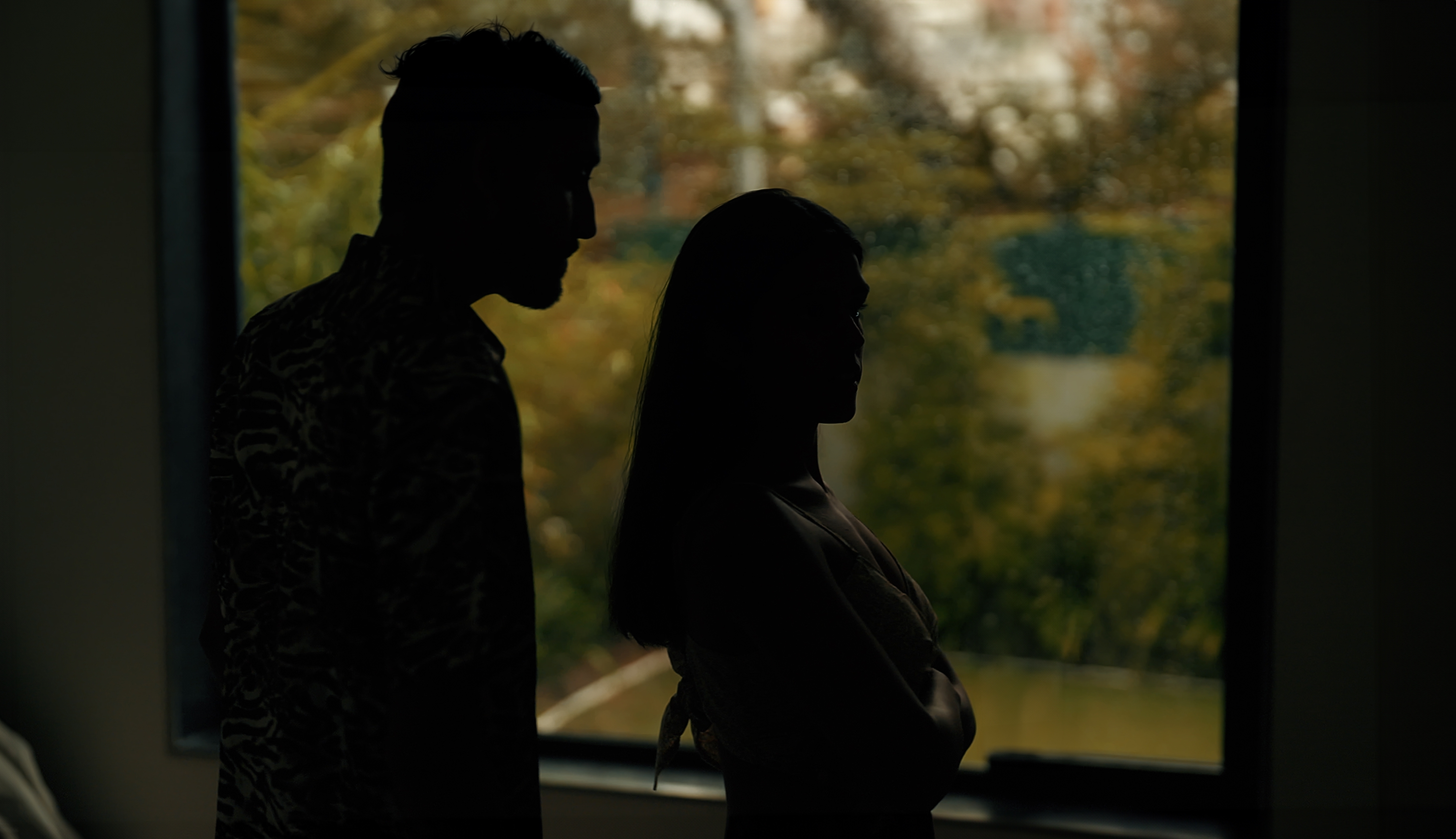 A silhouette of a couple standing near a window after an argument | Source: Shutterstock
