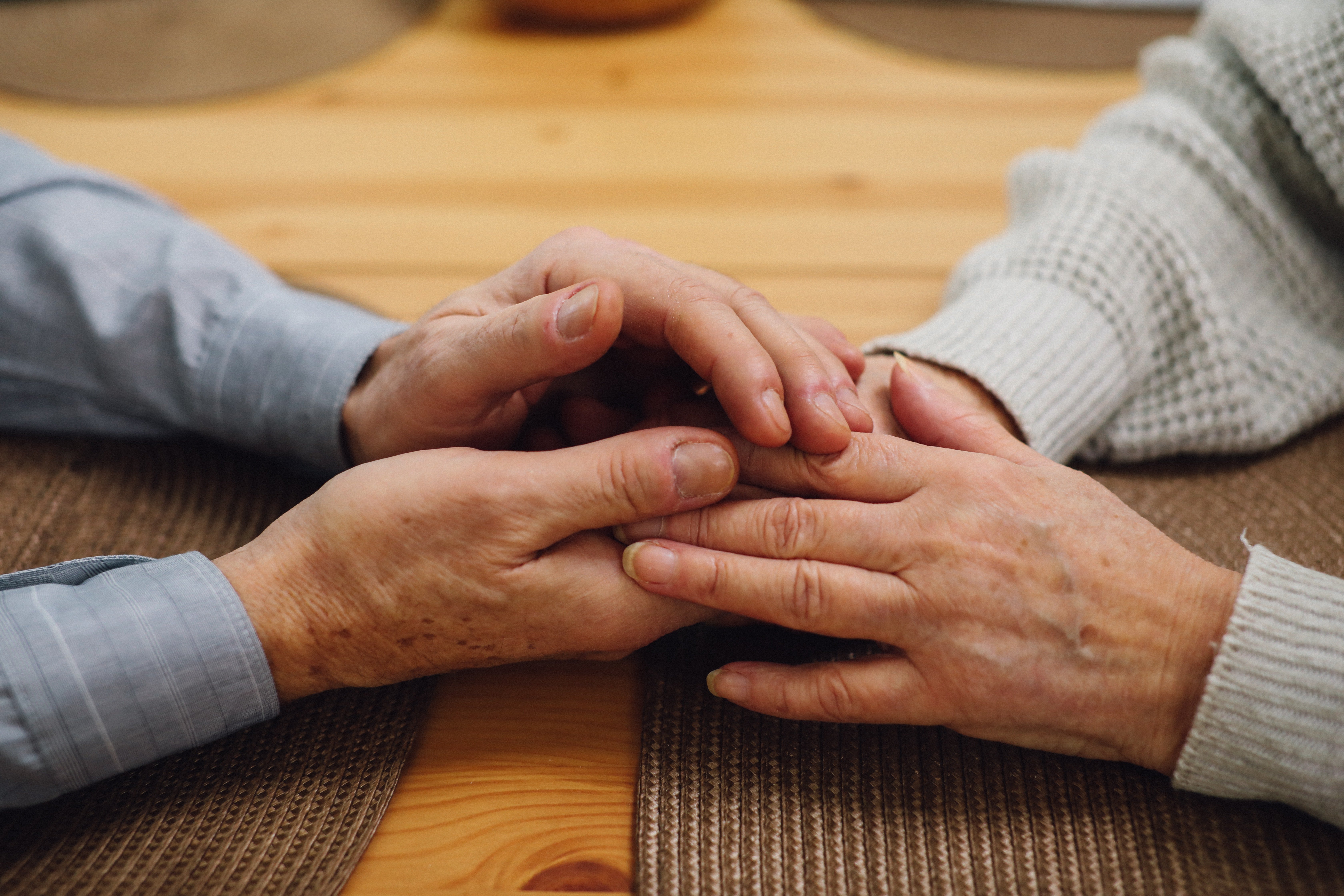 An older couple holding hands across a table. | Source: Pexels/ Tom Leishman