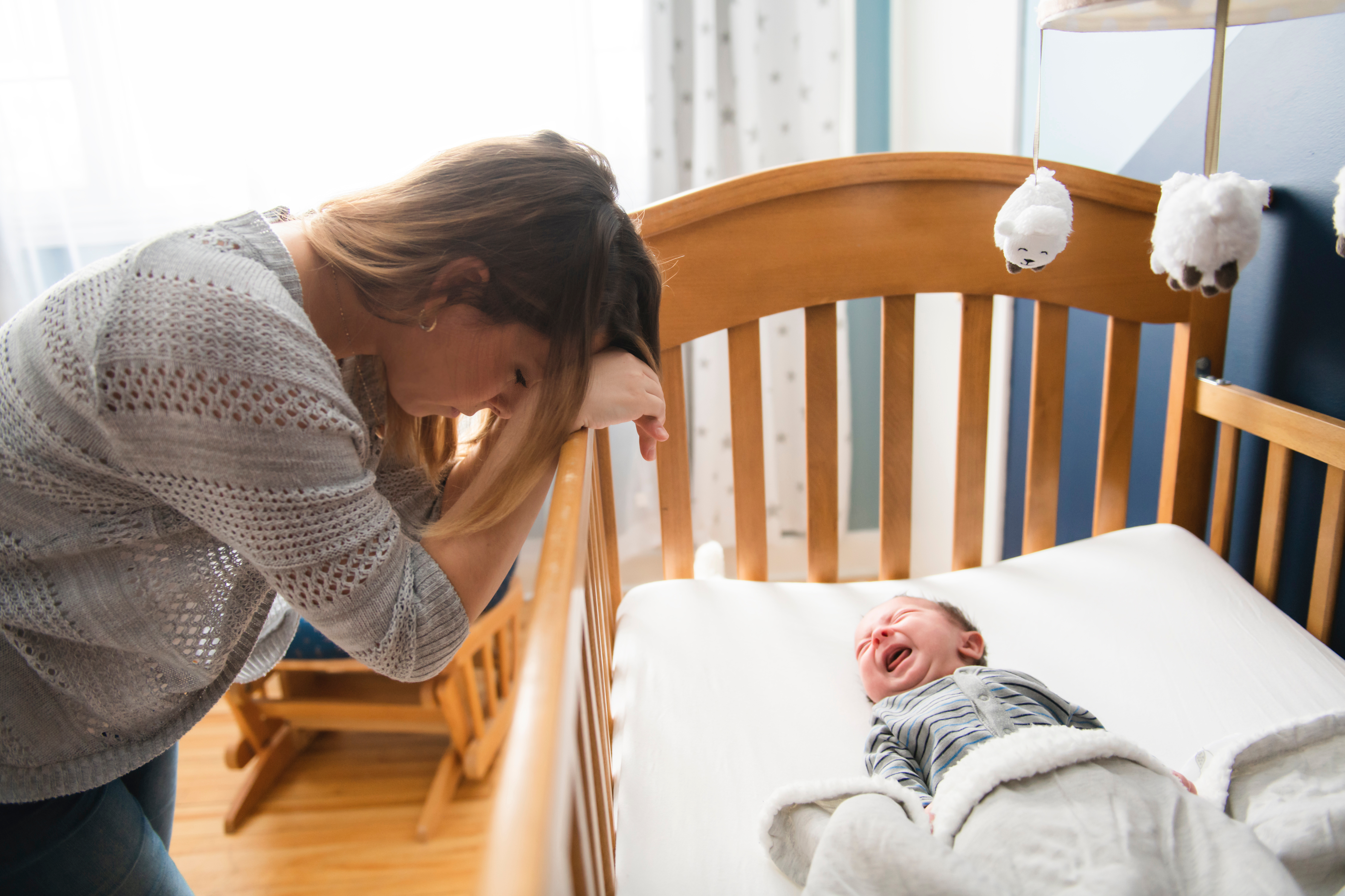A tired mother with a crying baby | Source: Shutterstock