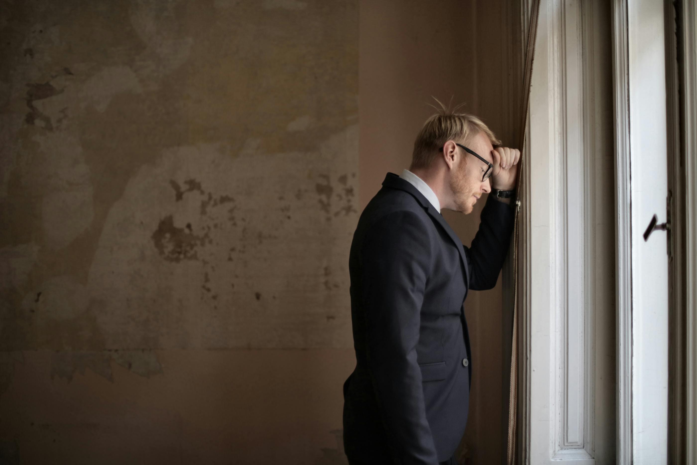 A businessman upset by a window | Source: Pexels