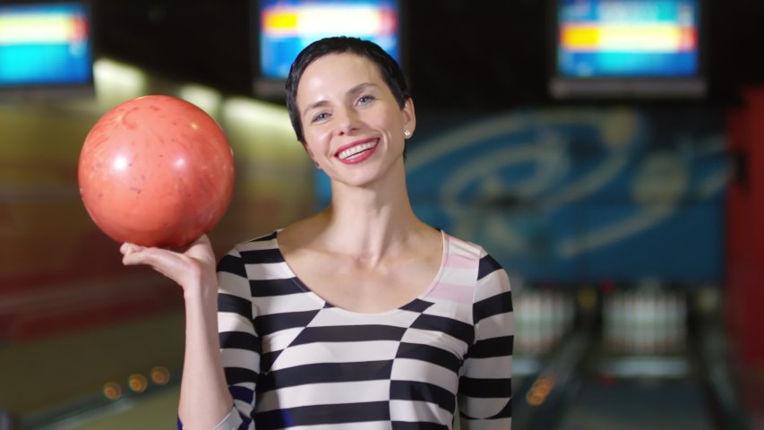 Image of woman holding a bowling ball | Photo: Shutterstock