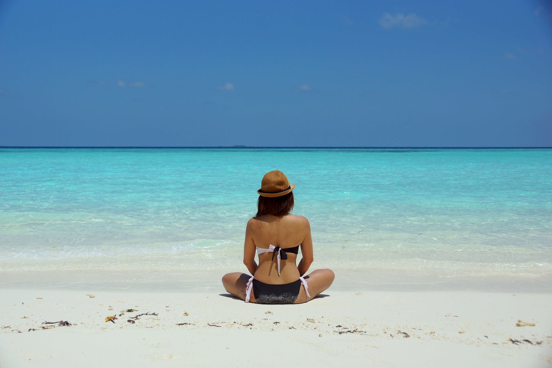Woman sitting on the beach in bikini | Source: Pexels
