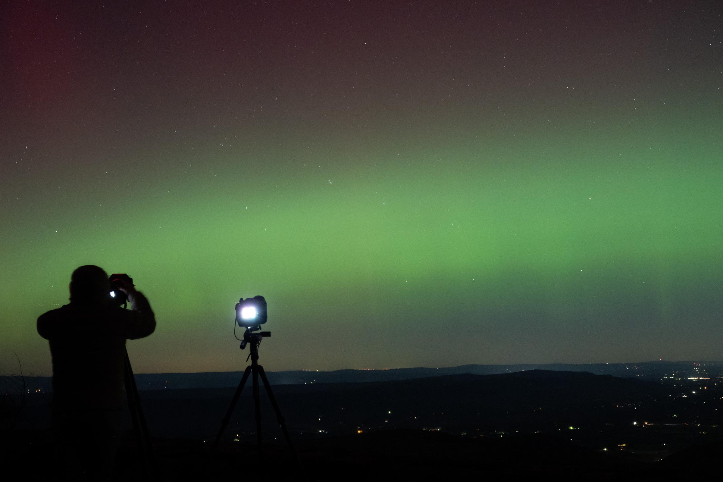 A photographer takes pictures of aurora borealis in Rileyville, Virginia on October 10, 2024 | Source: Getty Images