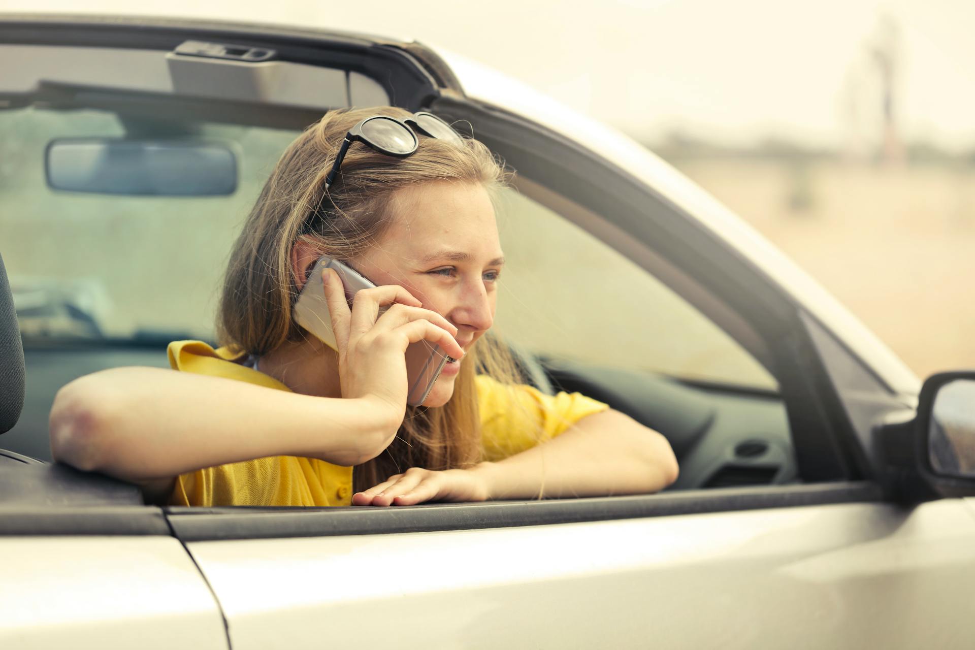 A woman in a car talking over the phone | Source: Pexels