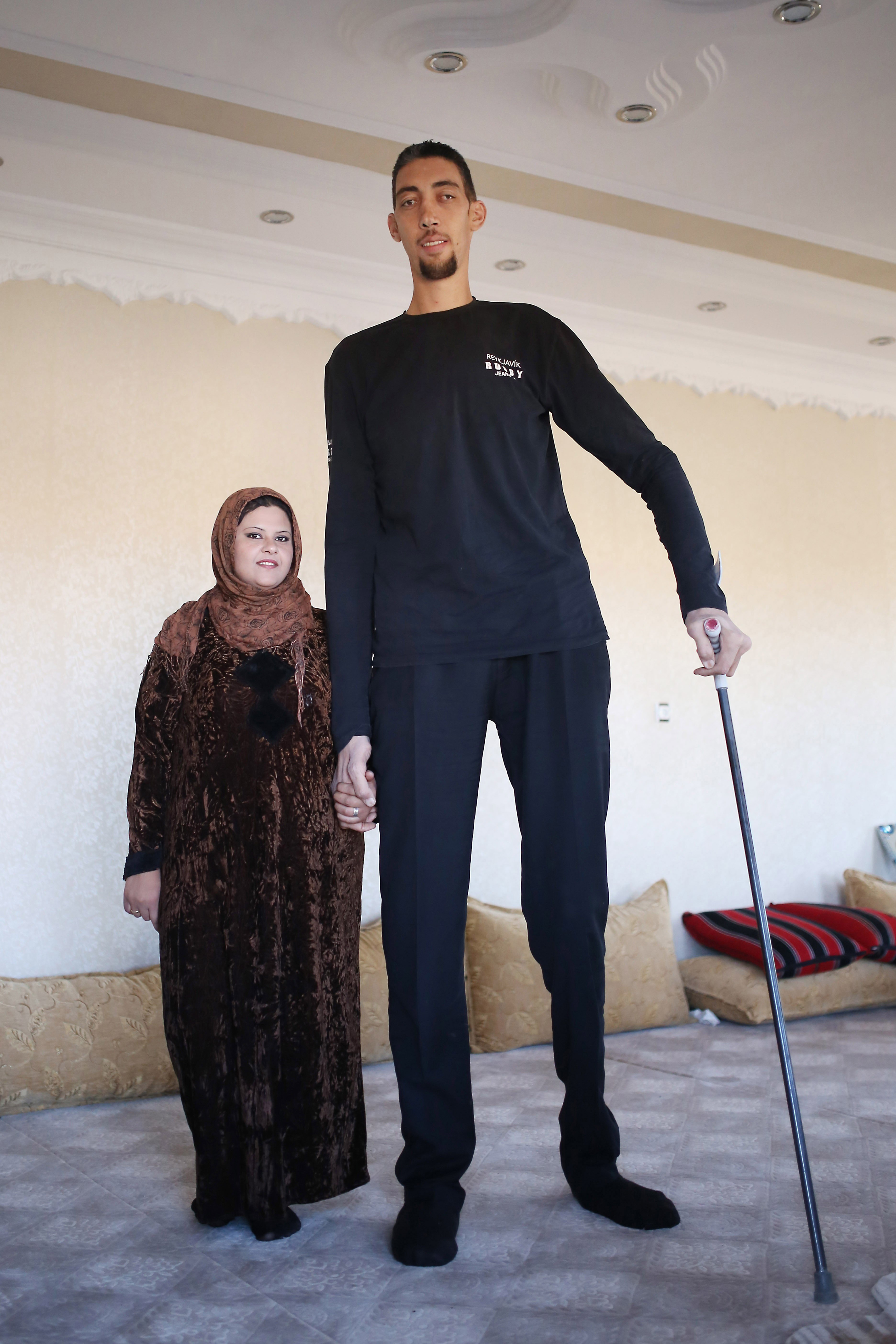 Sultan Kosen (R), world's tallest living male at 2.51 meters, poses with his wife, Merve Dibo (L), on their wedding anniversary in Mardin, Turkey, on November 9, 2014. | Source: Getty Images