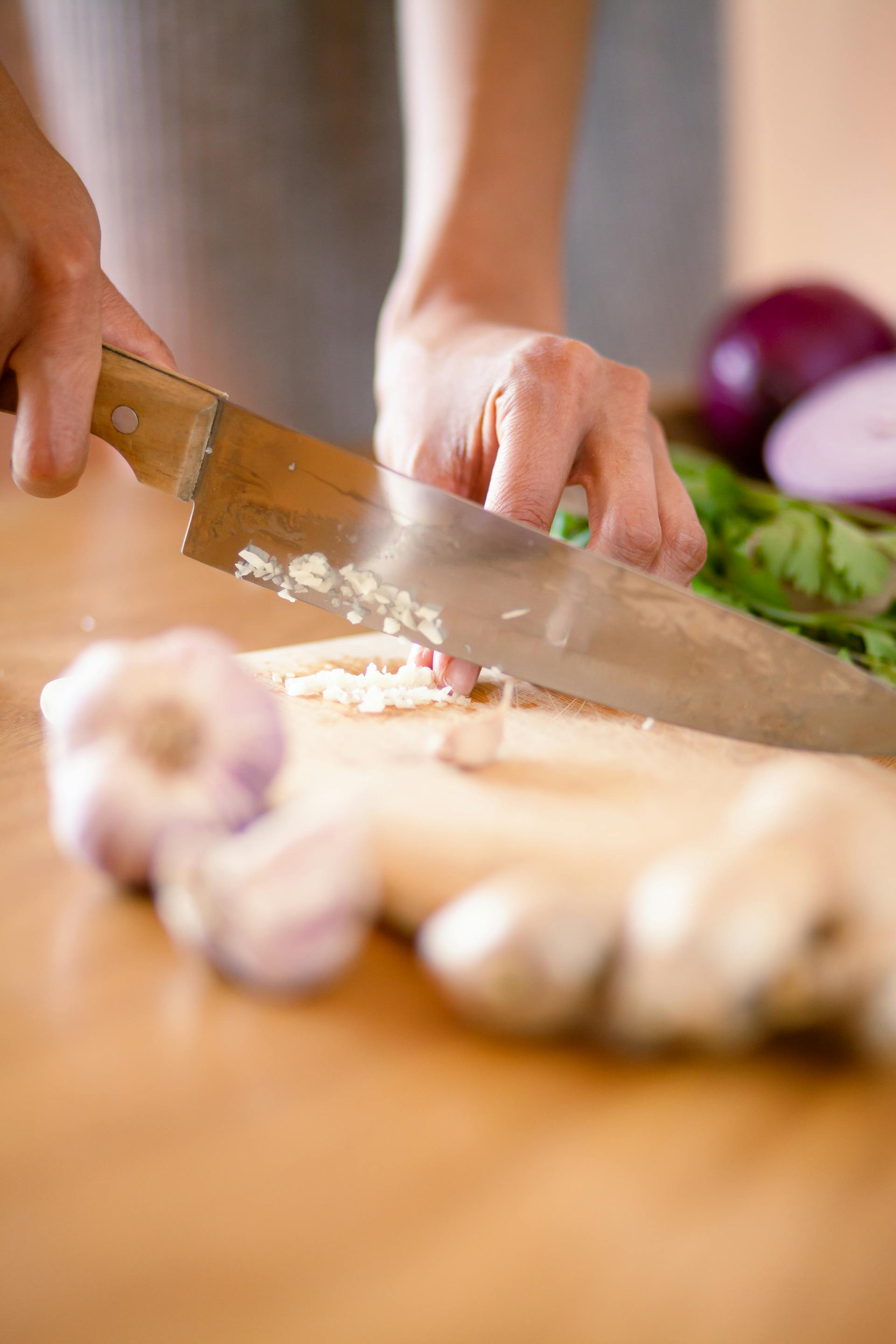A person chopping garlic | Source: Pexels