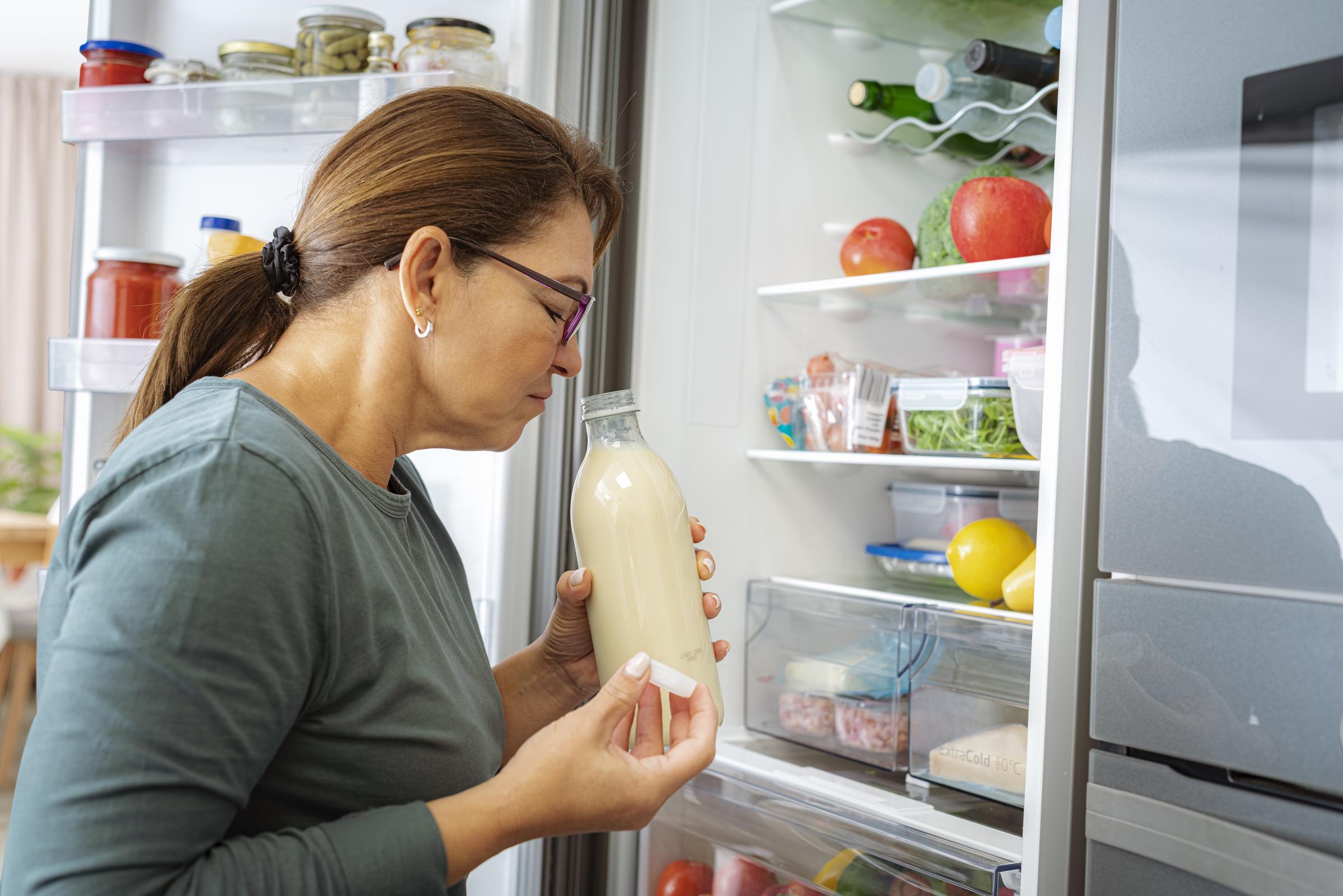 A woman doing a smell test of a beverage in her fridge | Source: Getty Images