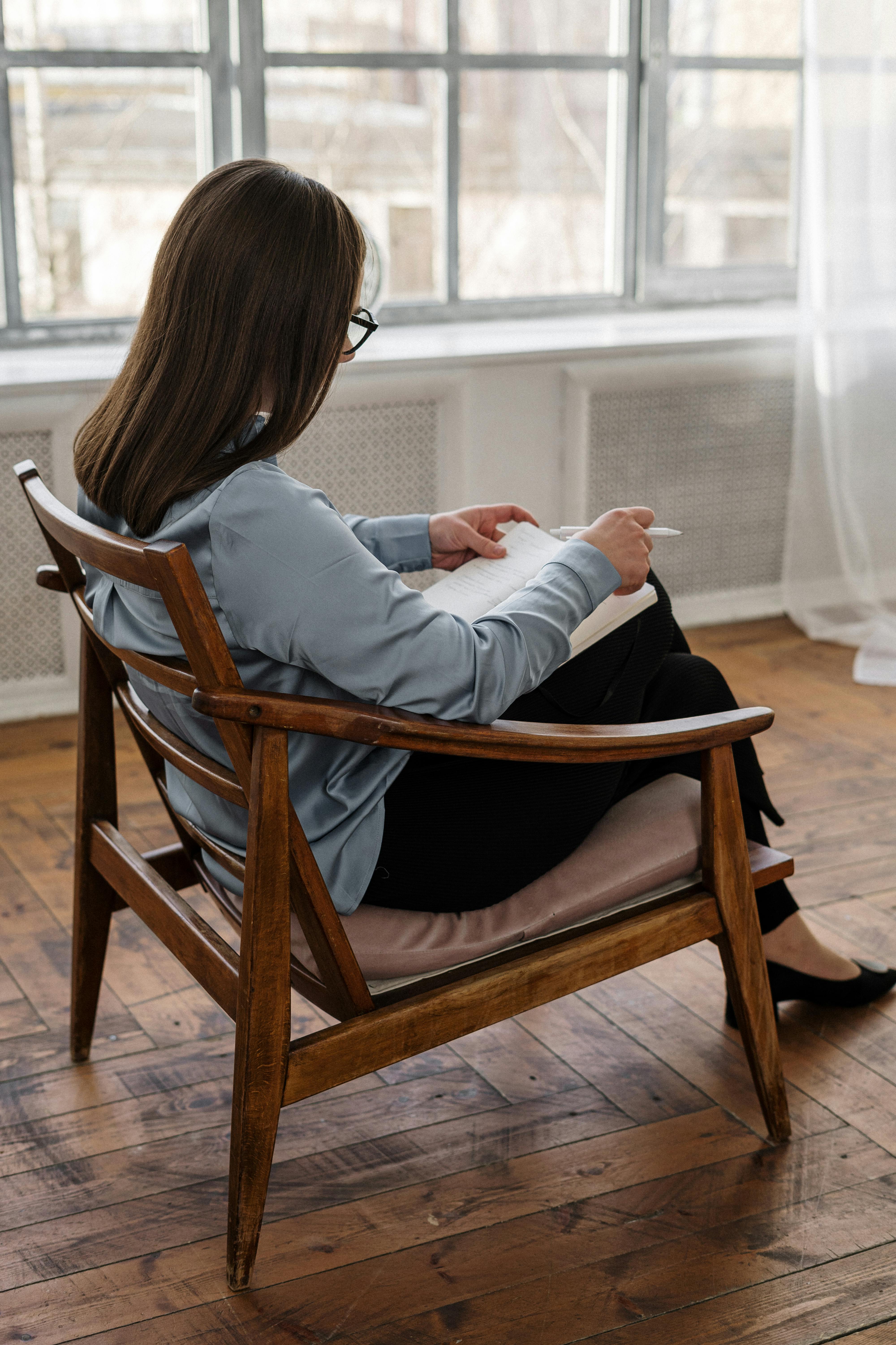 A therapist taking notes while talking to a client | Source: Pexels