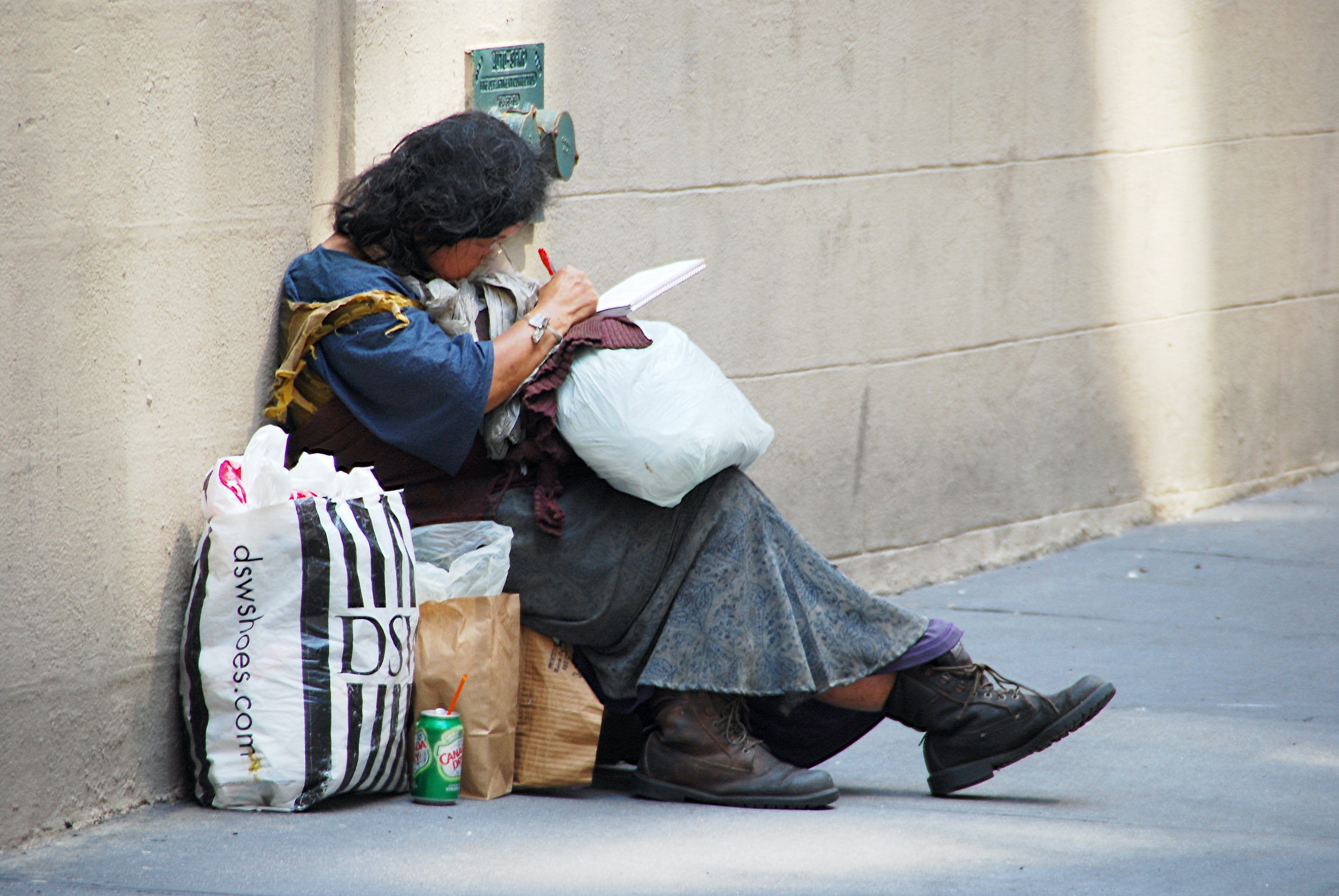 Mujer sentada en la calle con muchas bolsas. | Foto: Unsplash