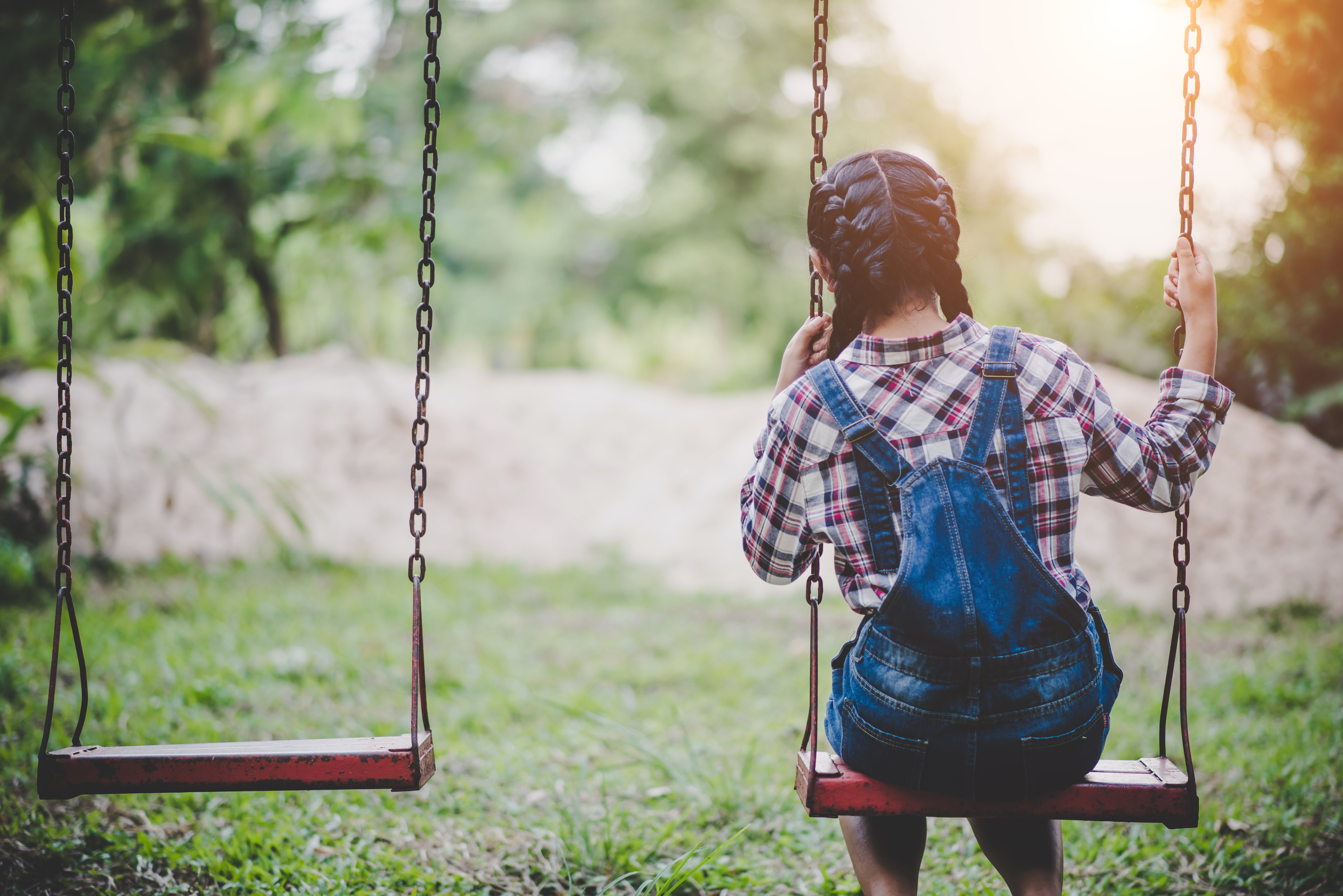 A young girl alone on a swing. | Source: Freepik. 