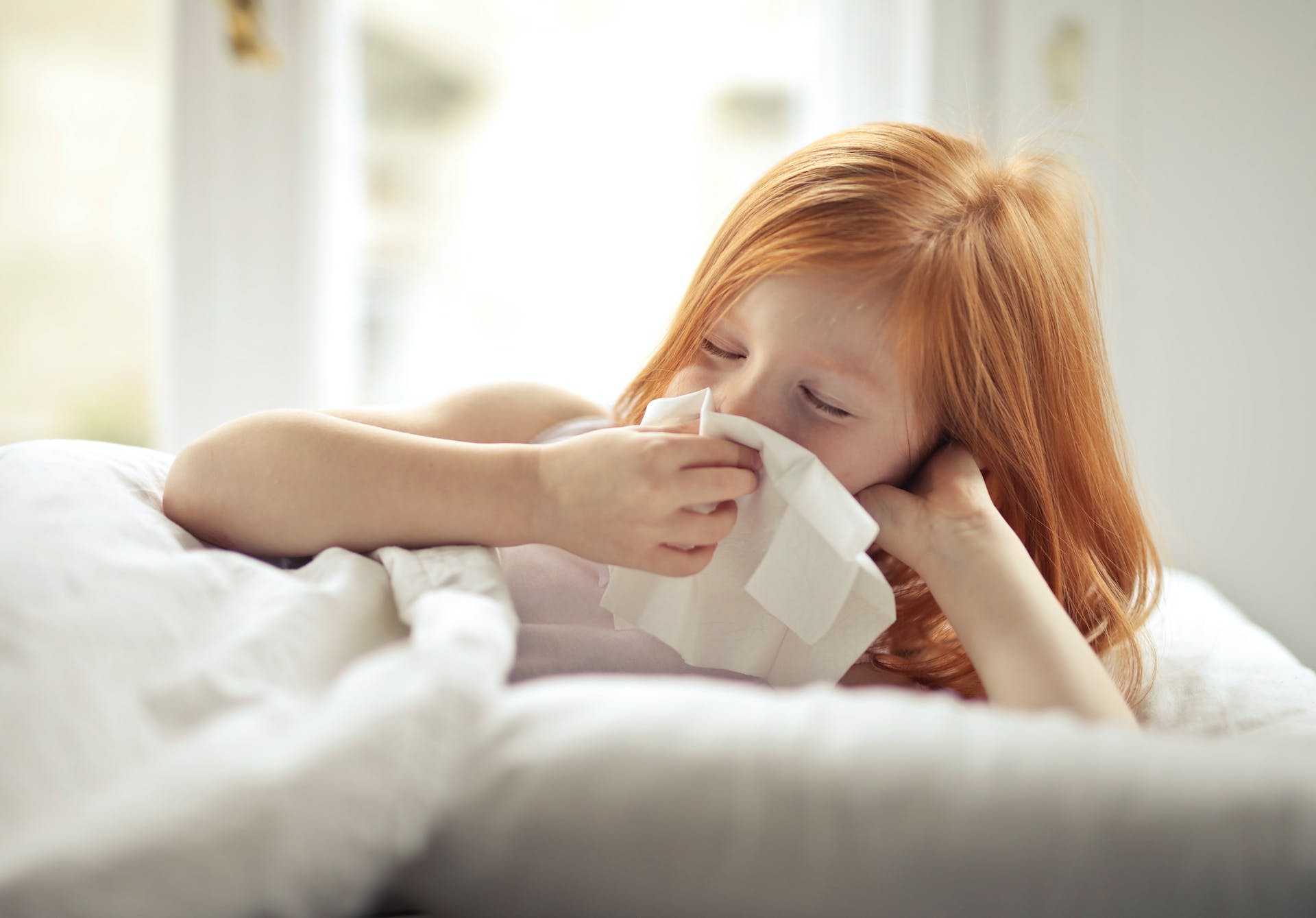 Little girl wiping her nose with a tissue | Source: Pexels