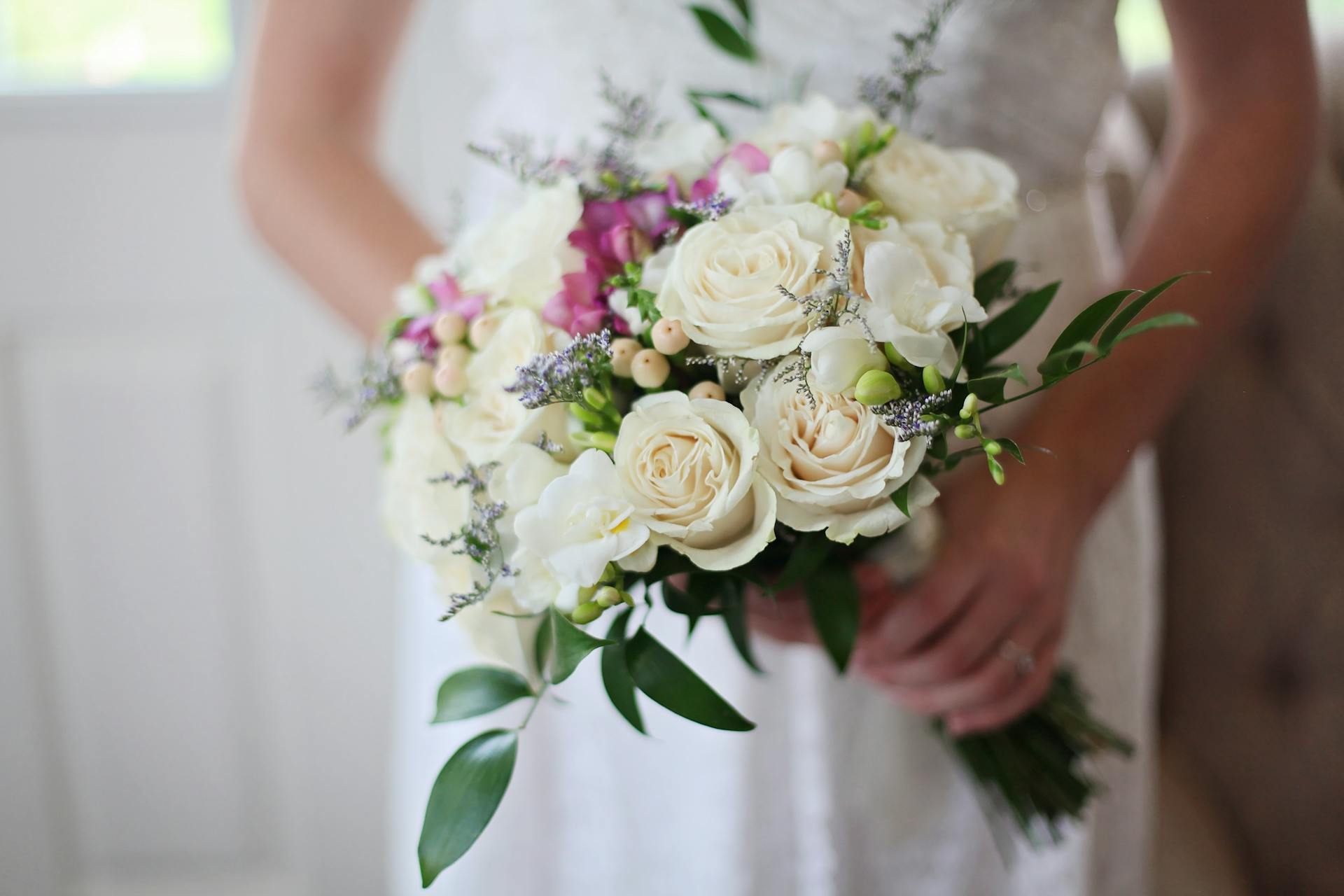 A bride holding a bouquet of roses | Source: Pexels