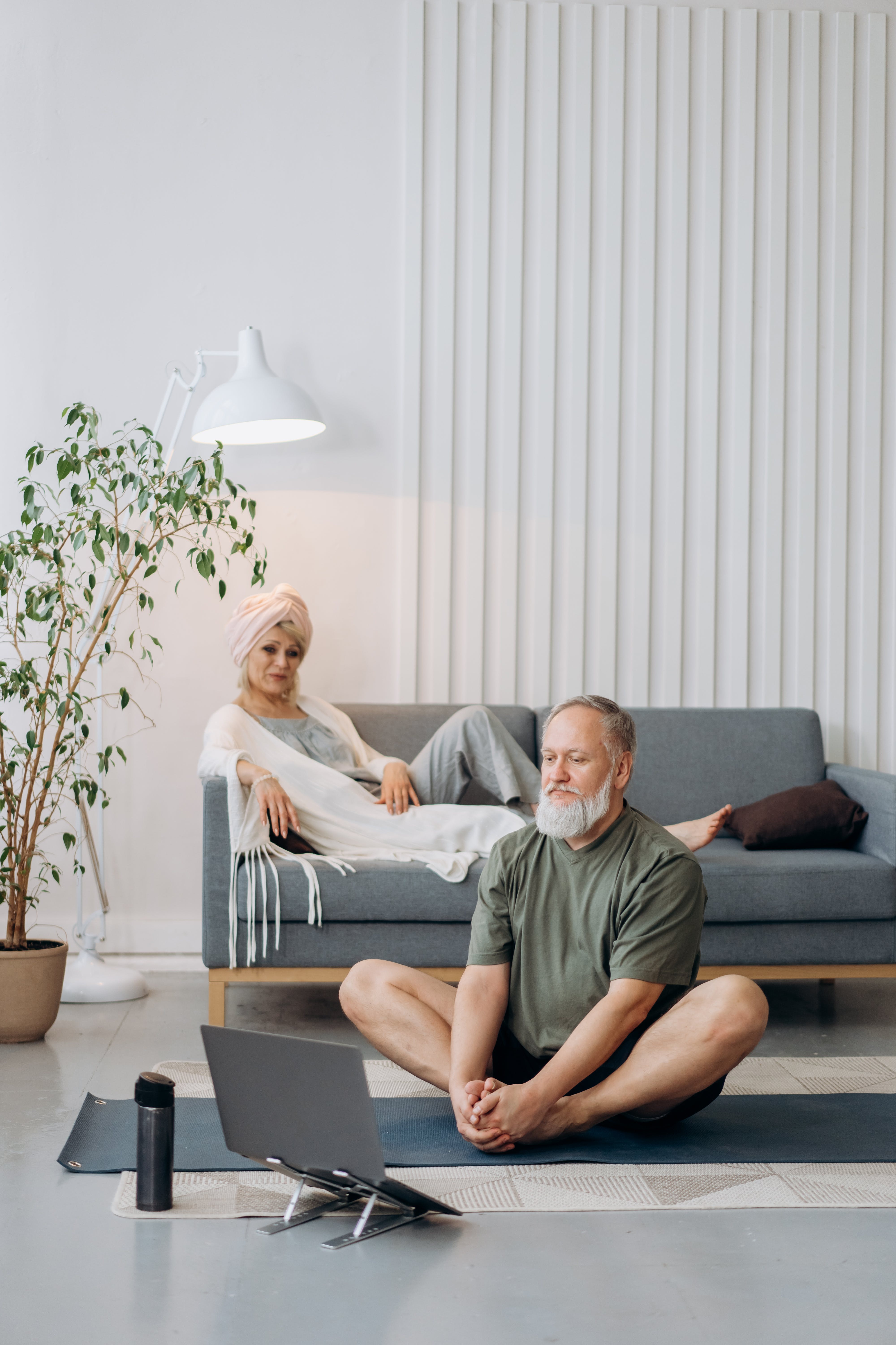 A woman sitting on the couch and a man sitting on the floor | Source: Pexels