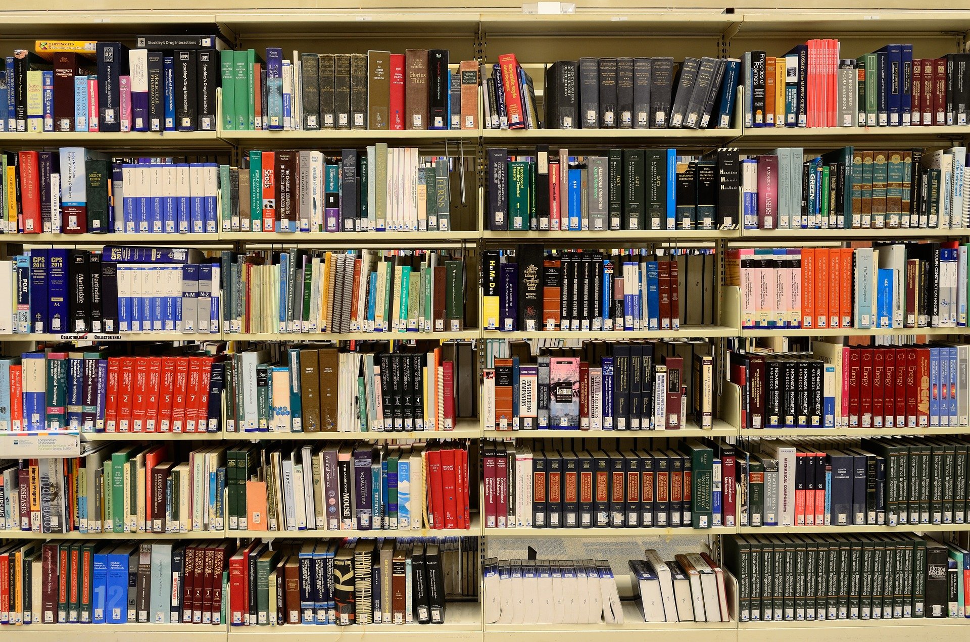 Pictured - Books stacked up on shelves in the library | Source: Pixabay