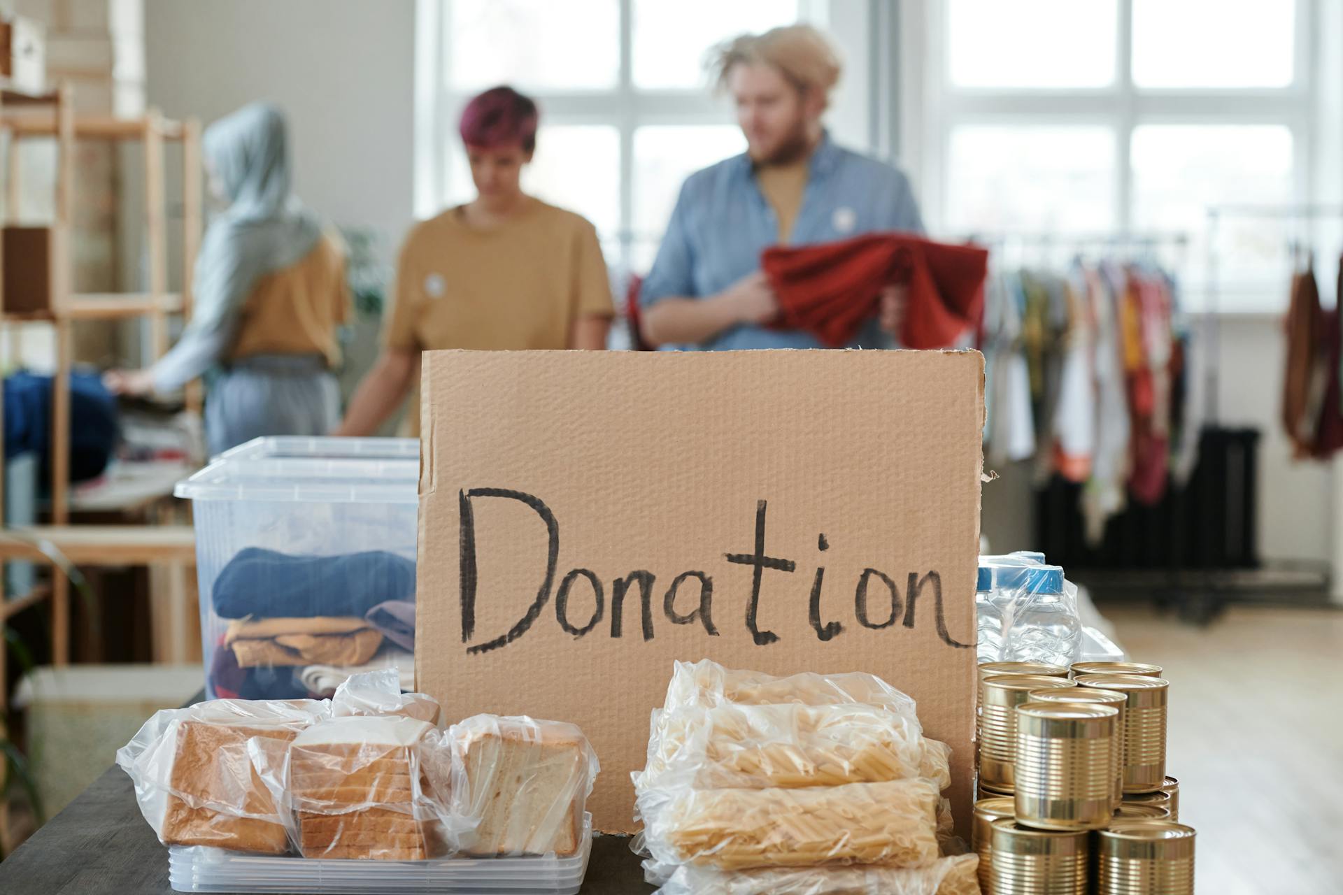Boxes of food placed next to a cardboard inscription reading "Donation" | Source: Pexels