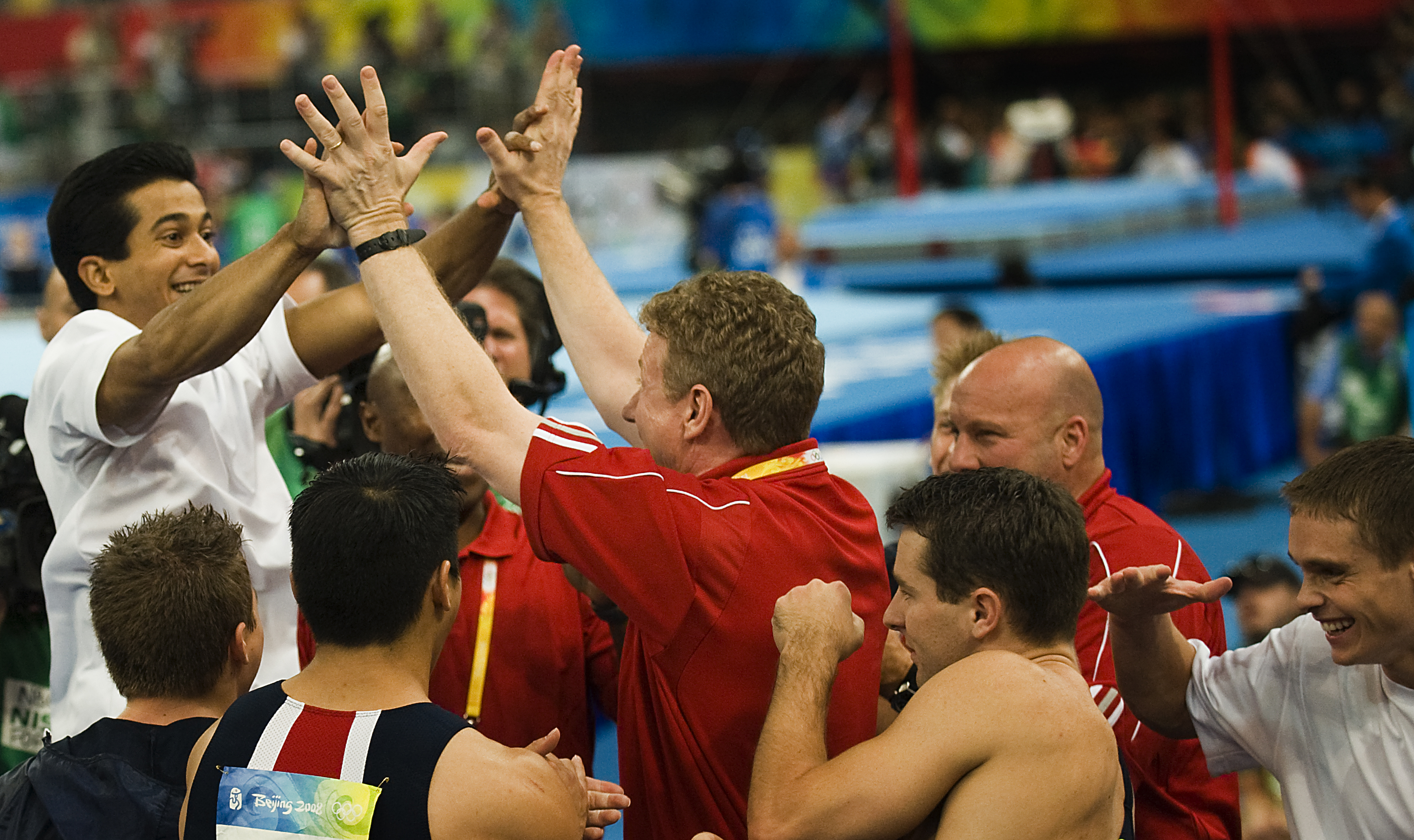 Raj Bhavsar and Team USA celebrates with coach Kevin Mazeika after winning bronze in the men's gymnastics team final at the Beijing 2008 Olympics on August 12, 2008 | Source: Getty Images