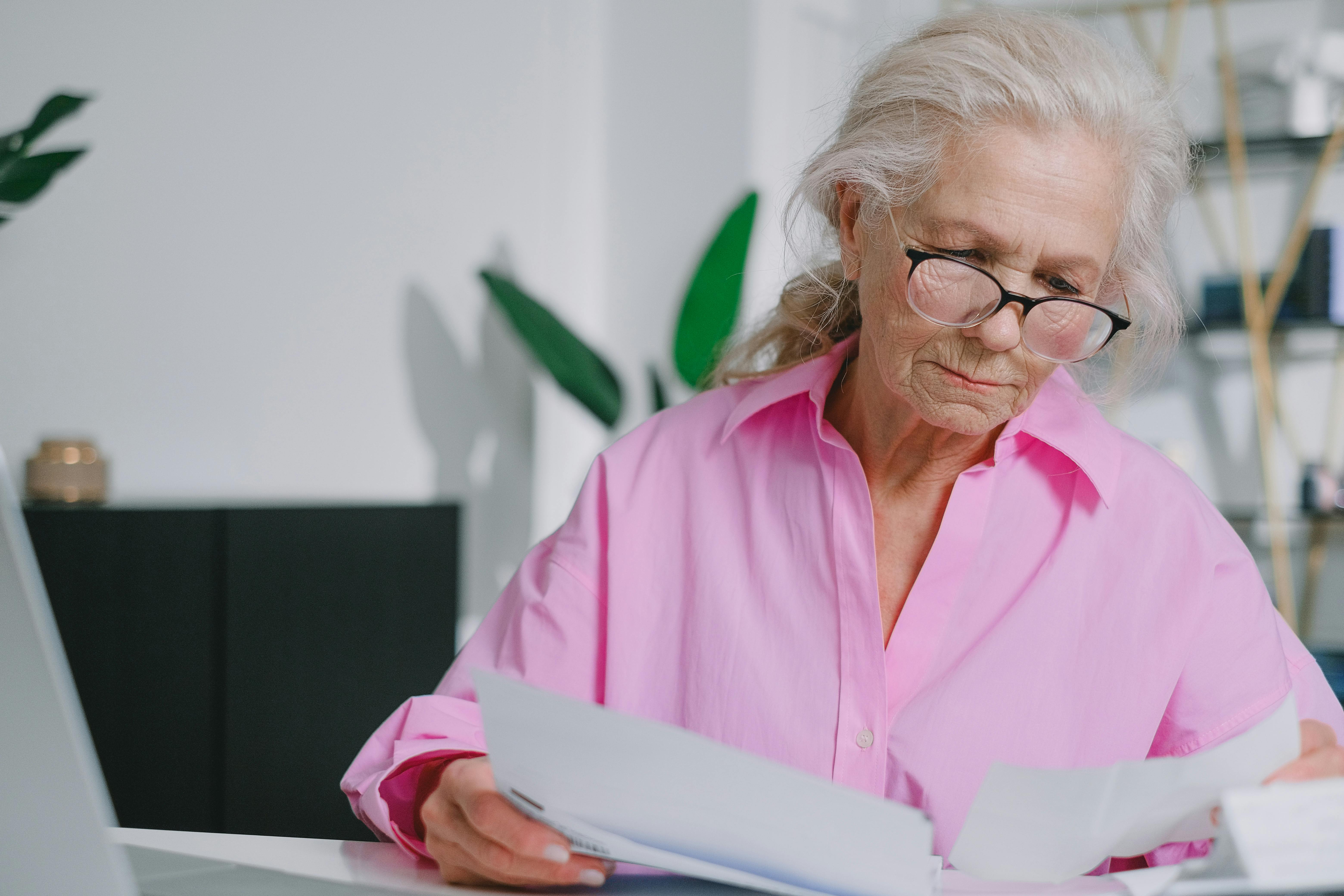 A woman wearing eyeglasses while reading a document | Source: Pexels