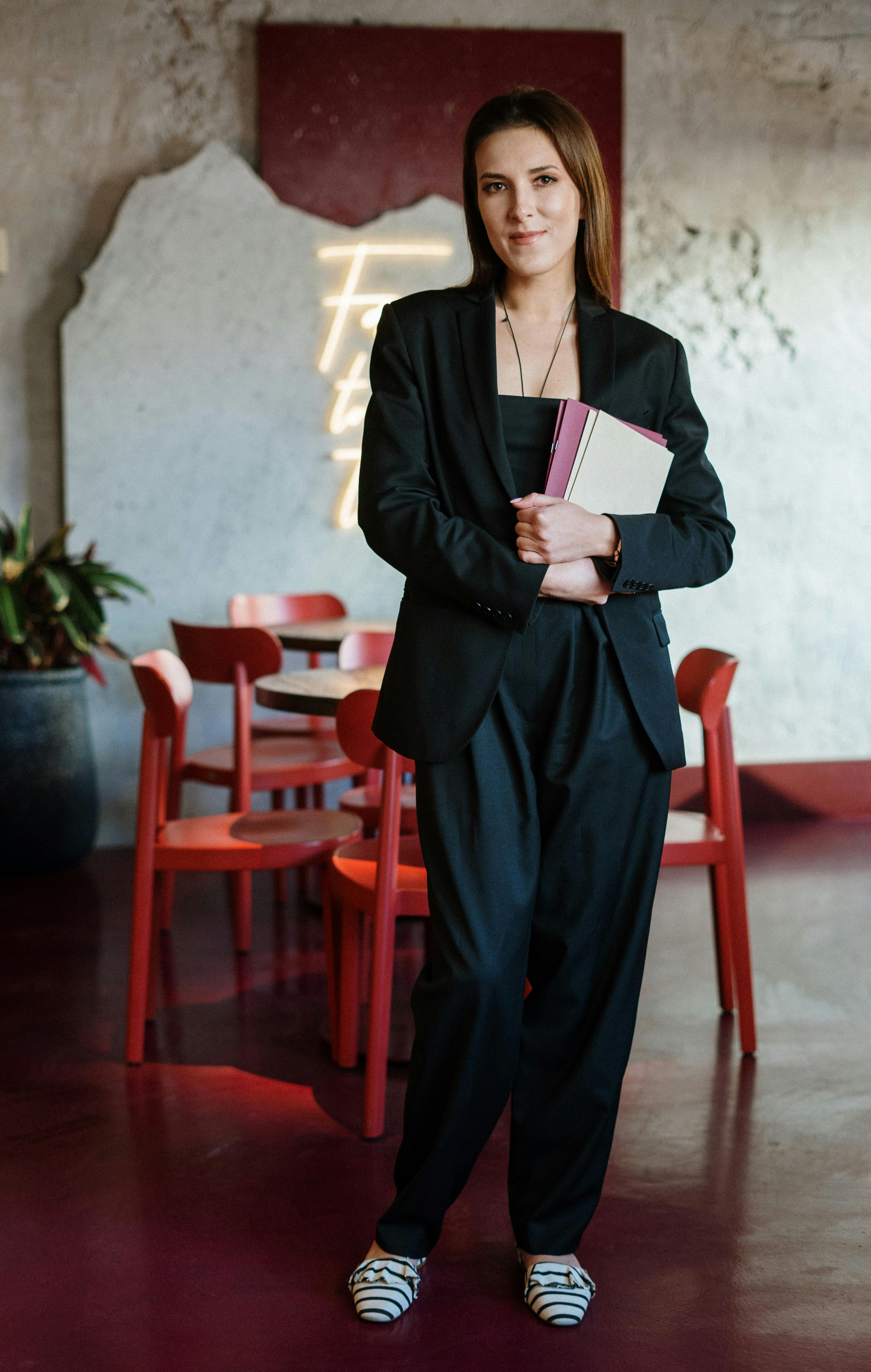 A woman smiling while holding a notebook | Source: Pexels